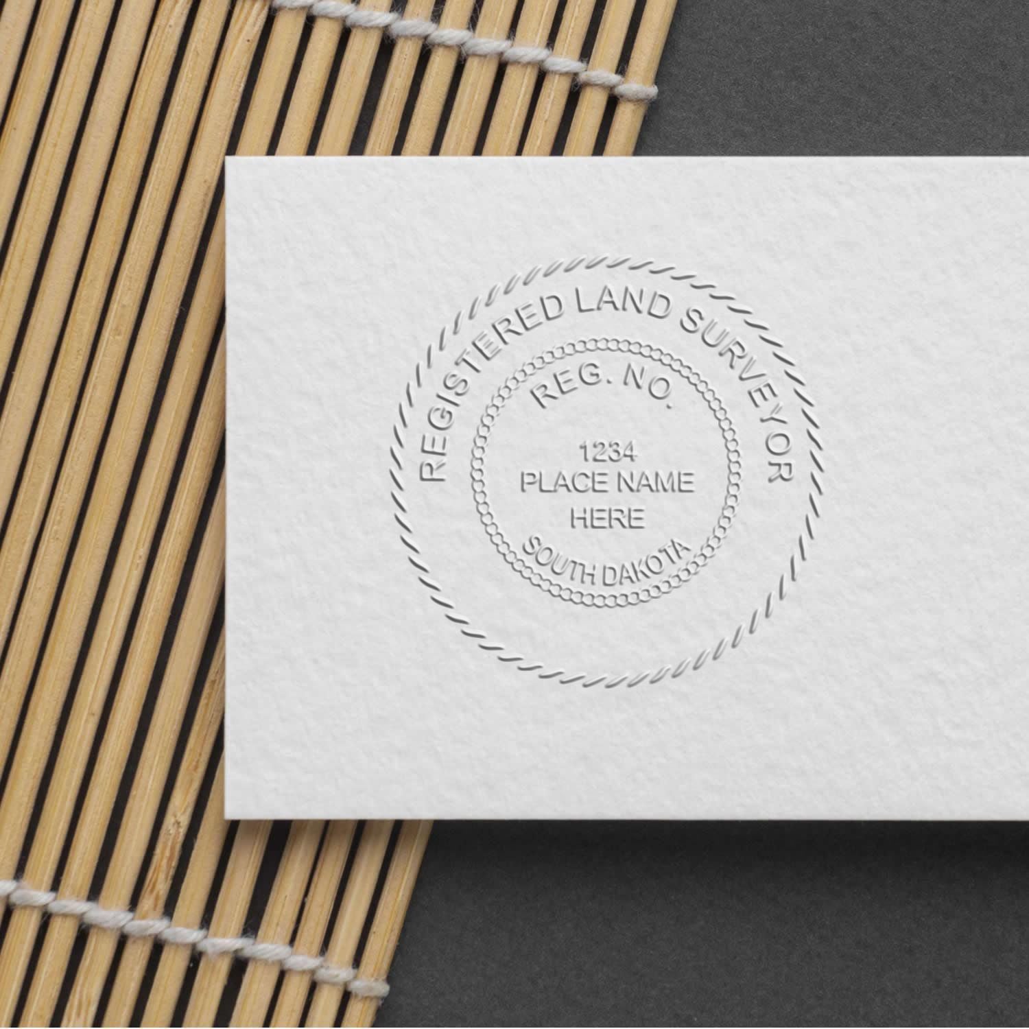 Embossed Registered Land Surveyor seal on white paper with South Dakota place name stamp.