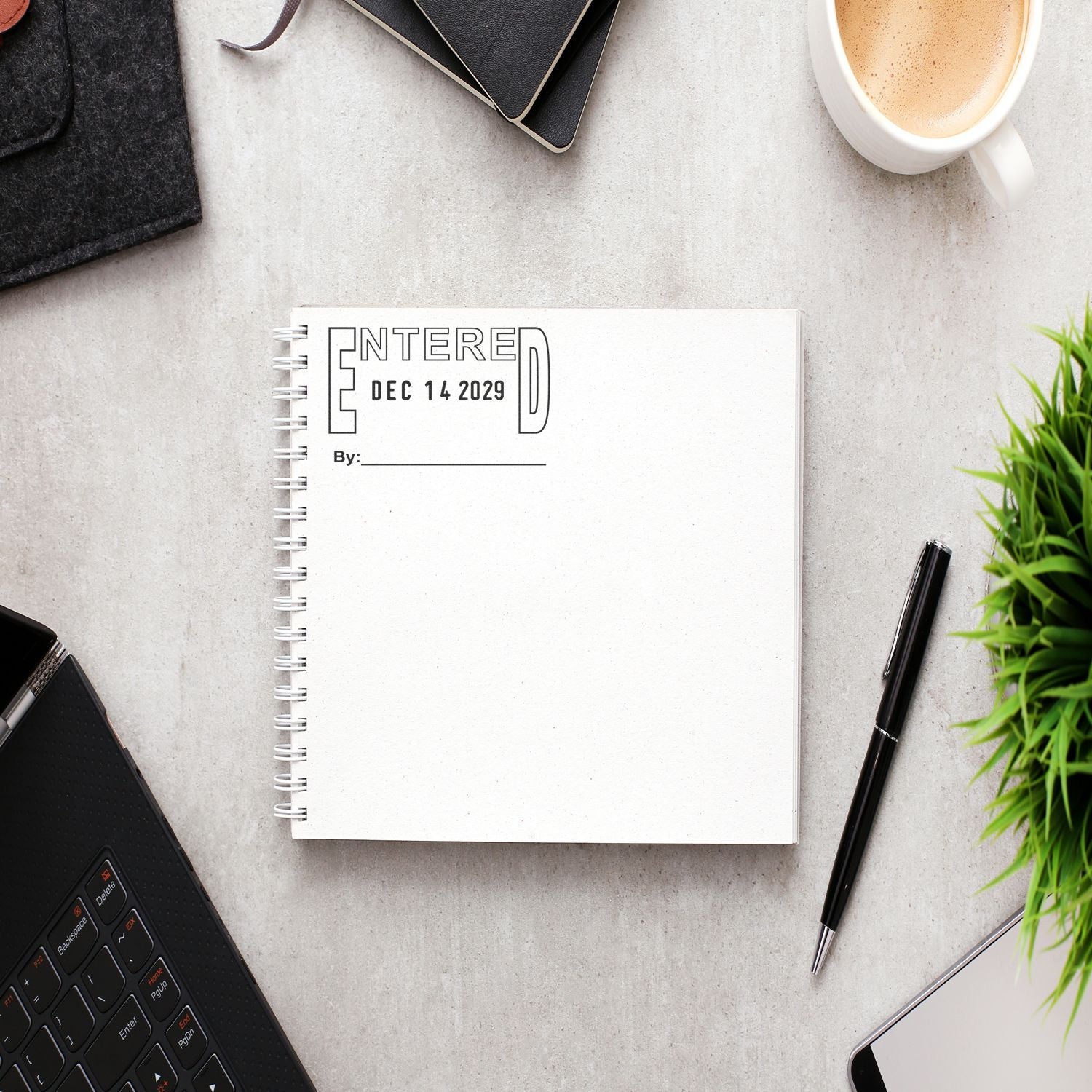 Flat lay office desk with blank spiral notebook, coffee cup, laptop, pen, and plant workspace arrangement
