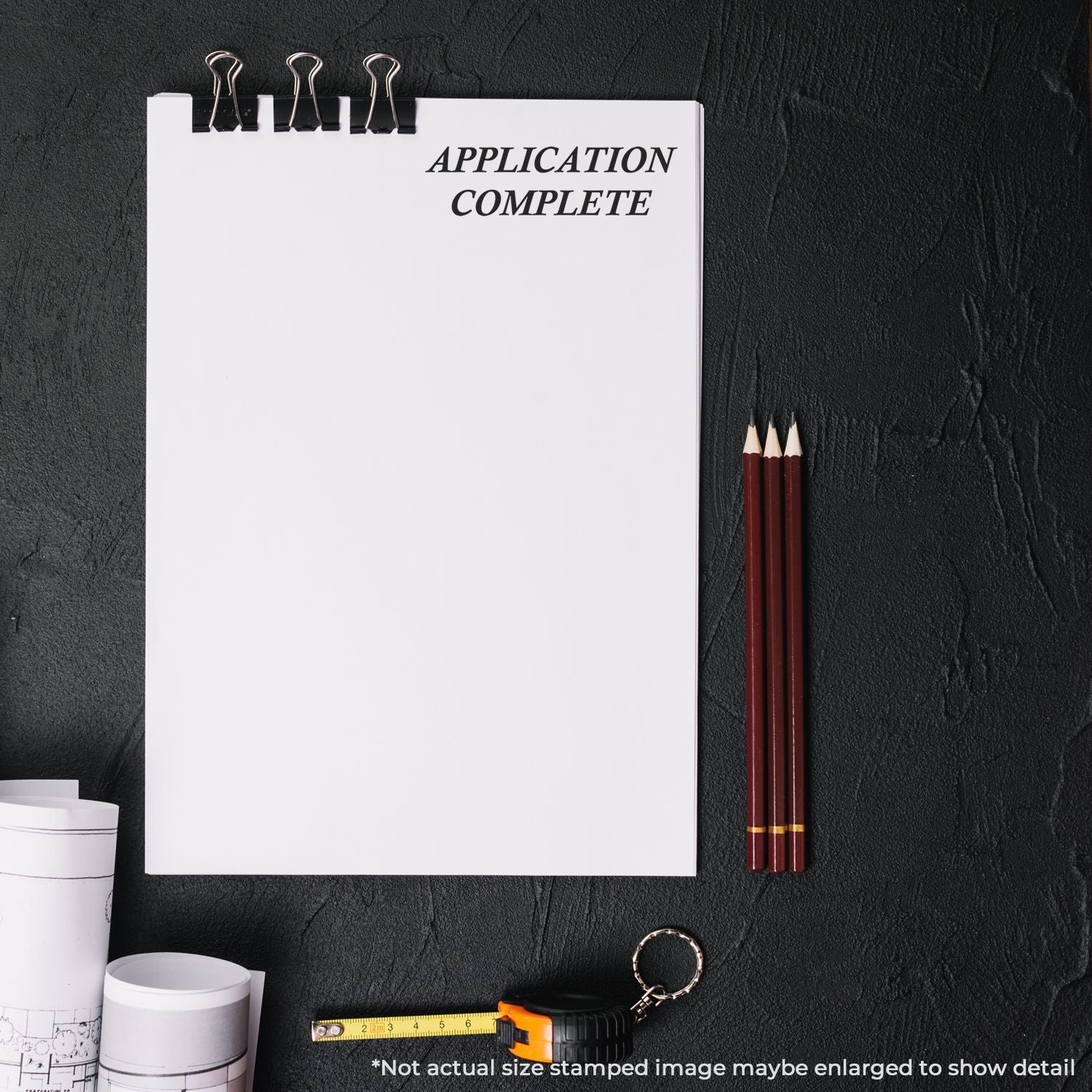 Application complete checklist on clipboard with pencils and tape measure, indicating completed job application documentation.