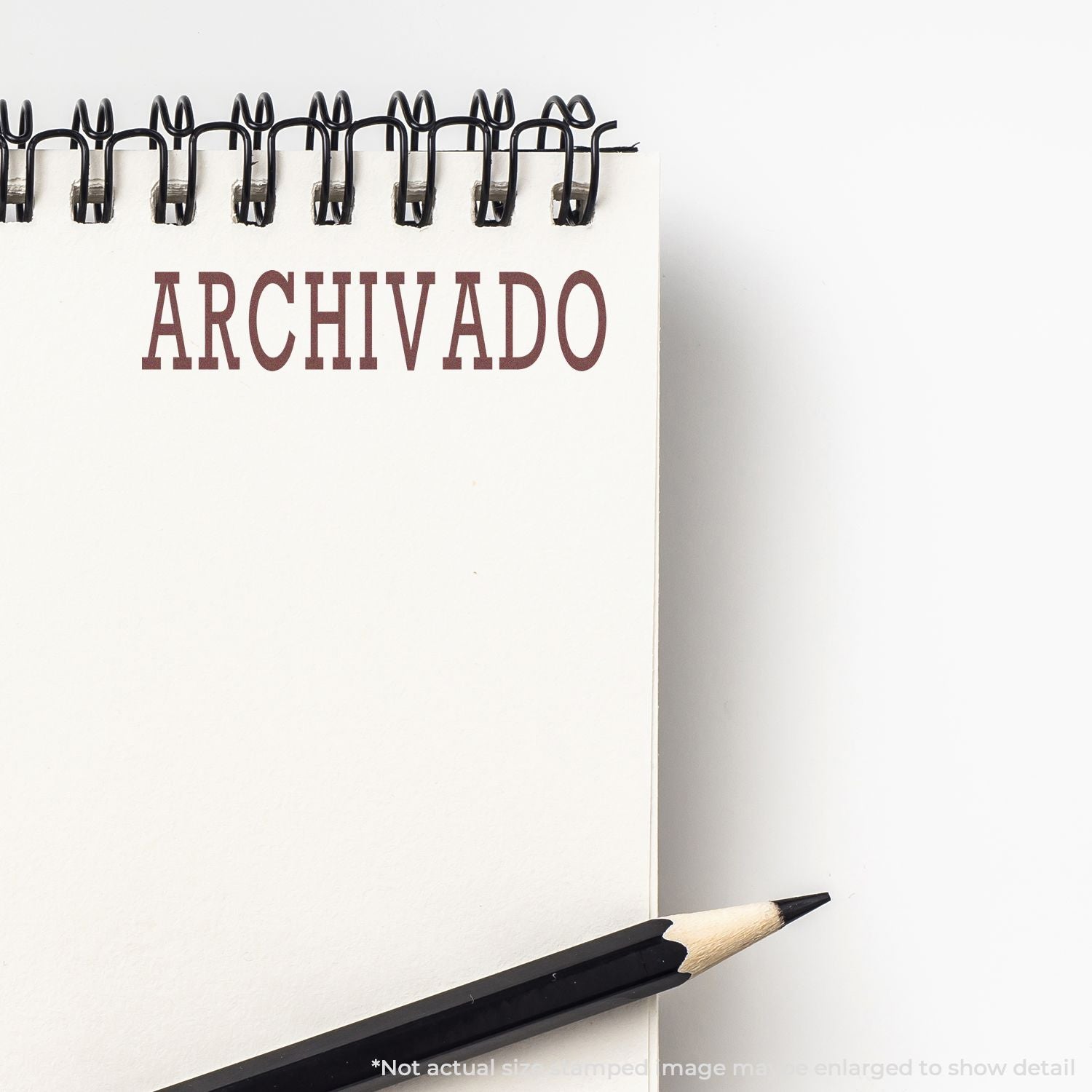 Blank spiral notebook labeled ARCHIVADO with pencil on white background, archival office concept.