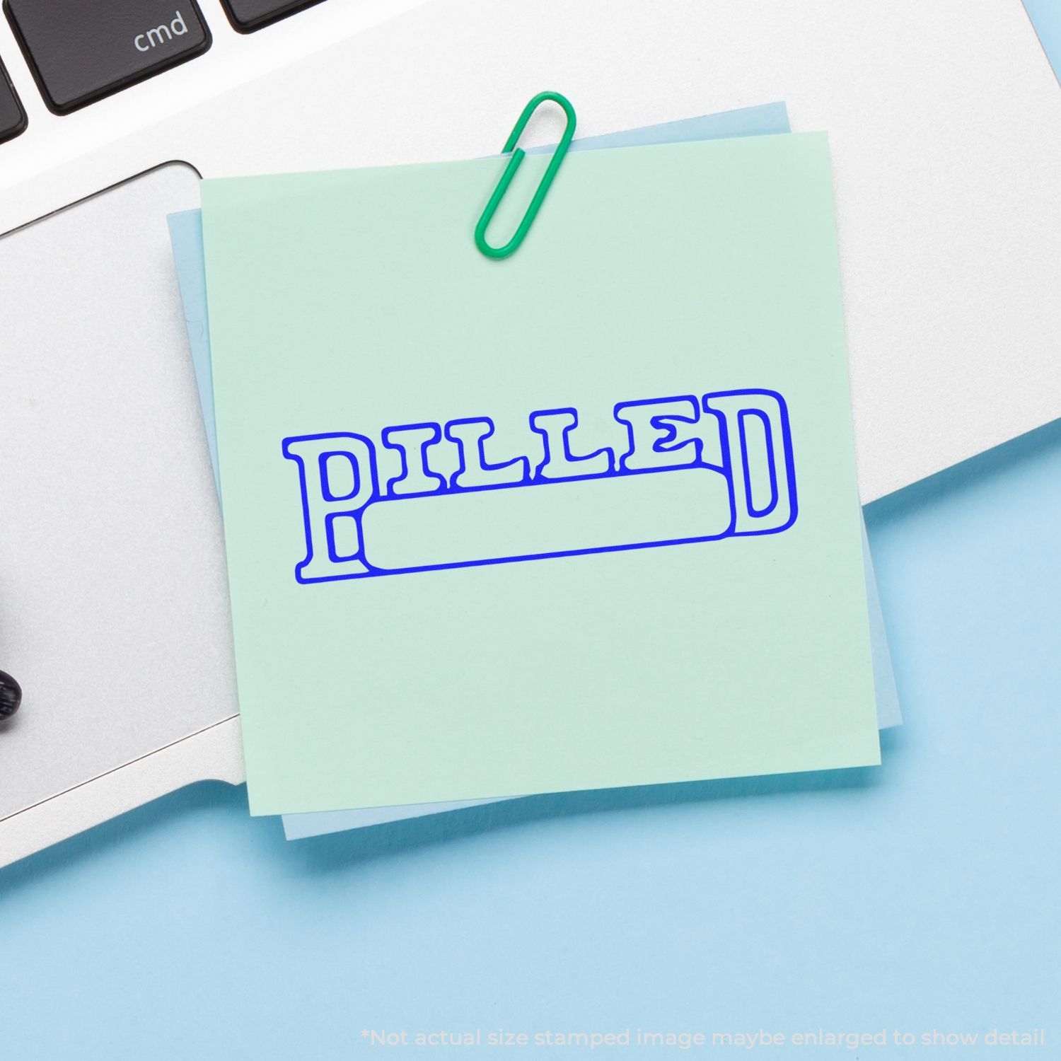 Pastel sticky notes clipped to a laptop keyboard with a green paperclip, office stationery background.
