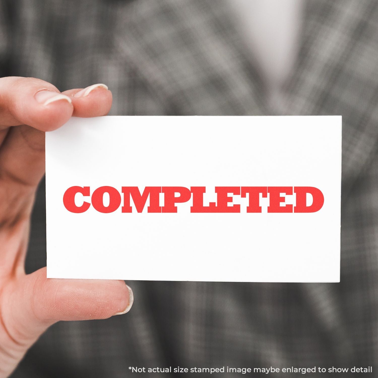 Hand holding a card that says COMPLETED, signaling job completion and successful process status.