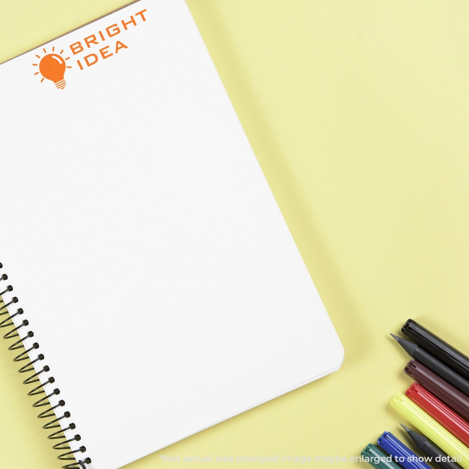 Bright Idea notebook with colorful pencils on yellow background, promoting creative journaling and idea generation.