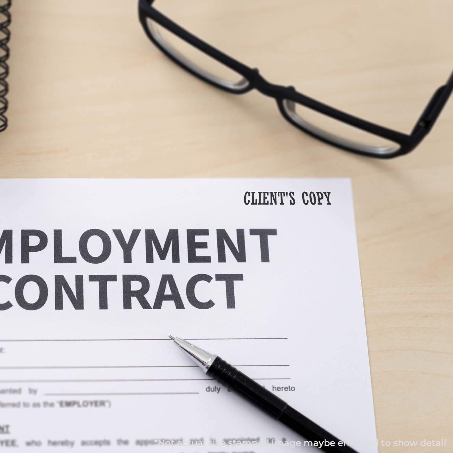 Employment contract document on desk with glasses and pen, client copy for business or hiring paperwork.