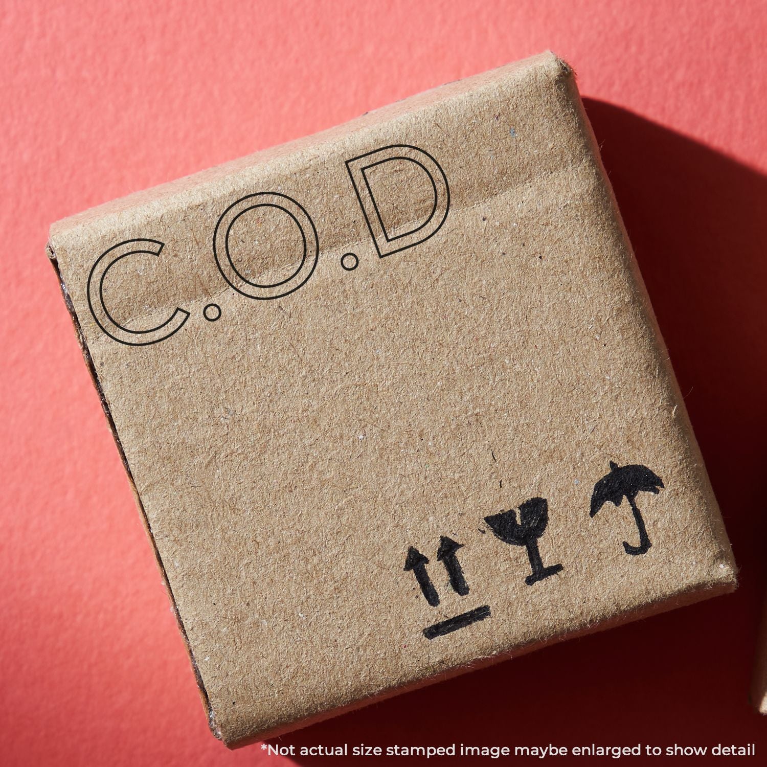 Close-up of stamped cardboard industrial packaging label showing code COD and shipping handling symbols for logistics identification.