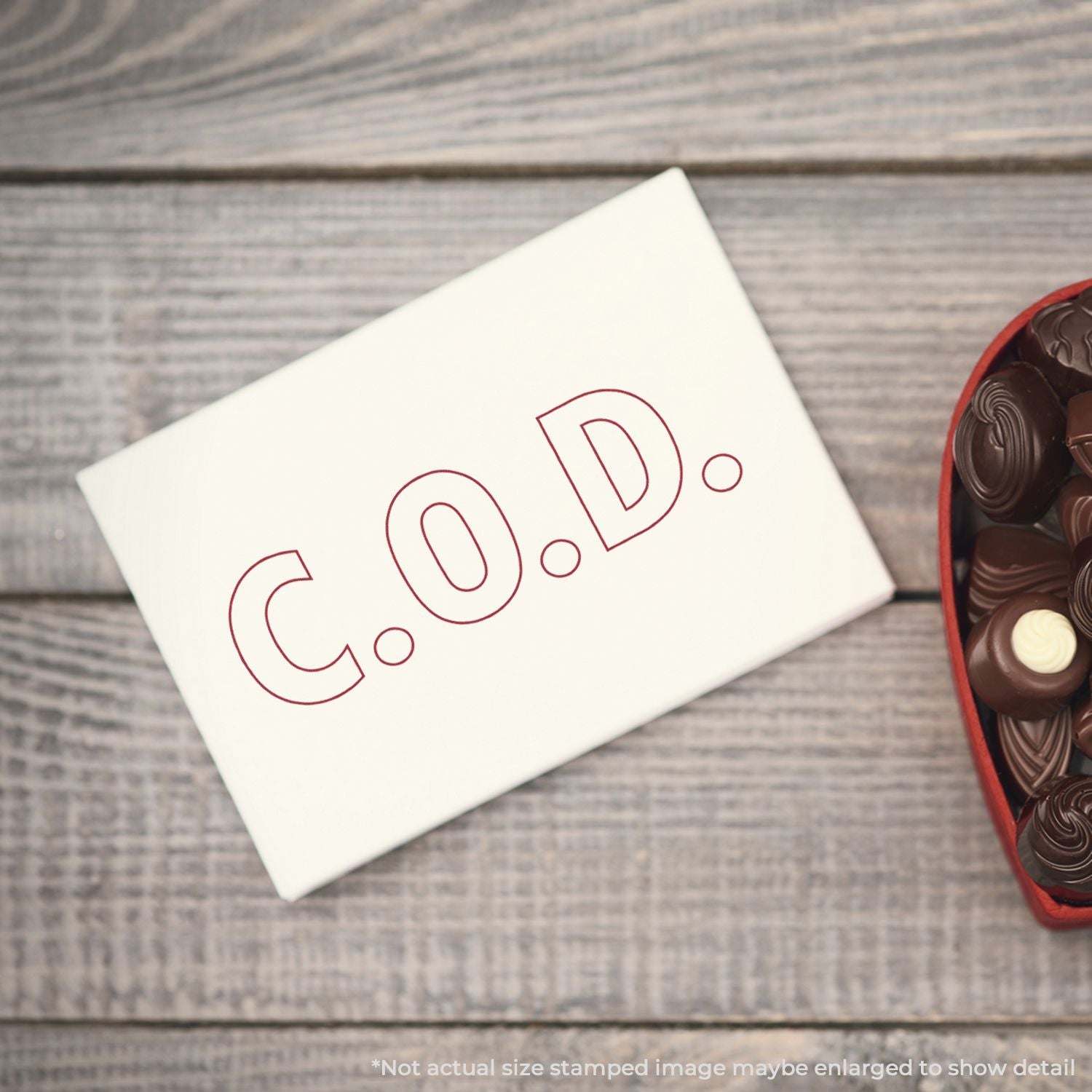 White card stamped with C O D letters next to a chocolate gift box, ideal for a sweet greeting and gifting message.