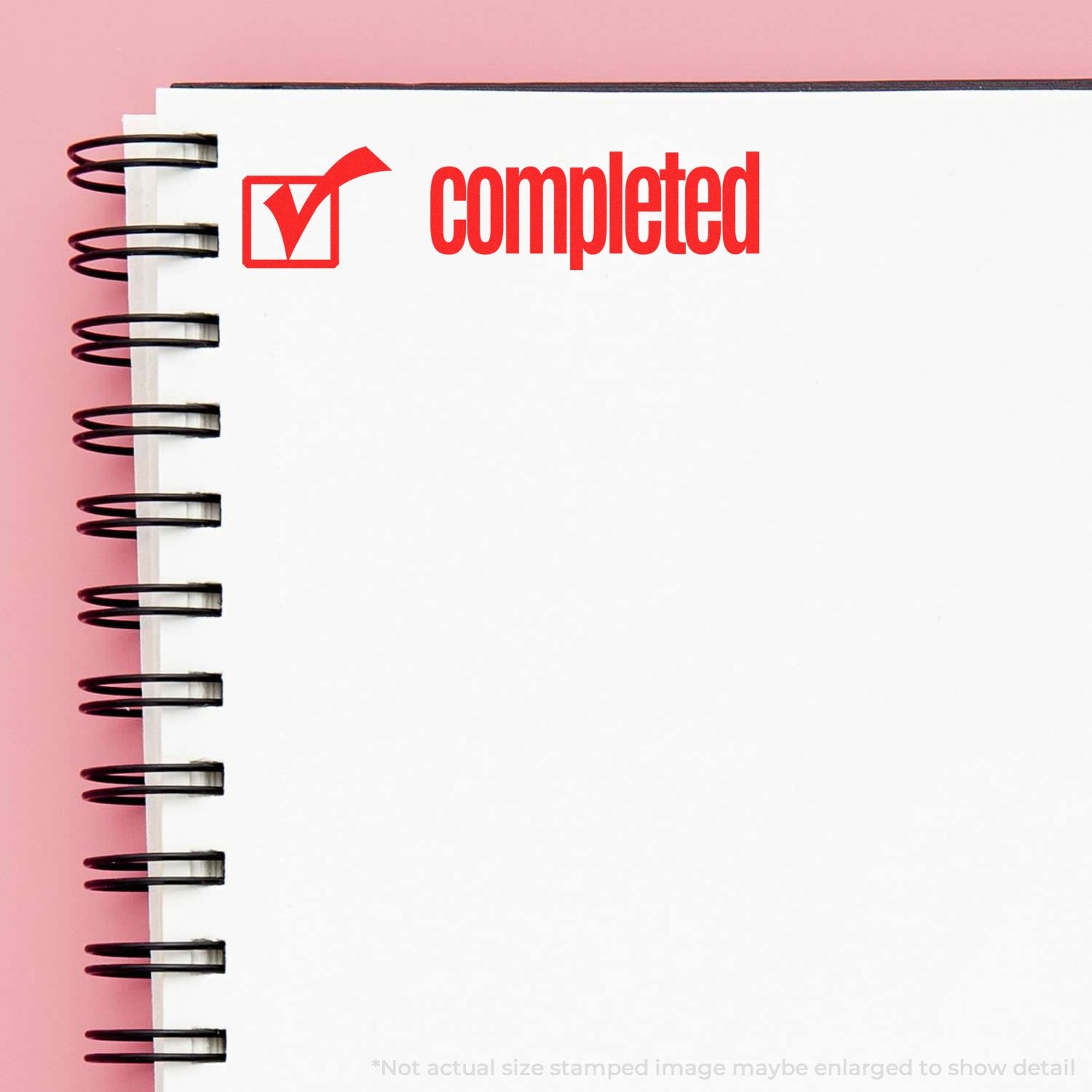 Red completed checkmark stamped on a blank spiral notebook page, symbolizing finished tasks and productivity checklist.