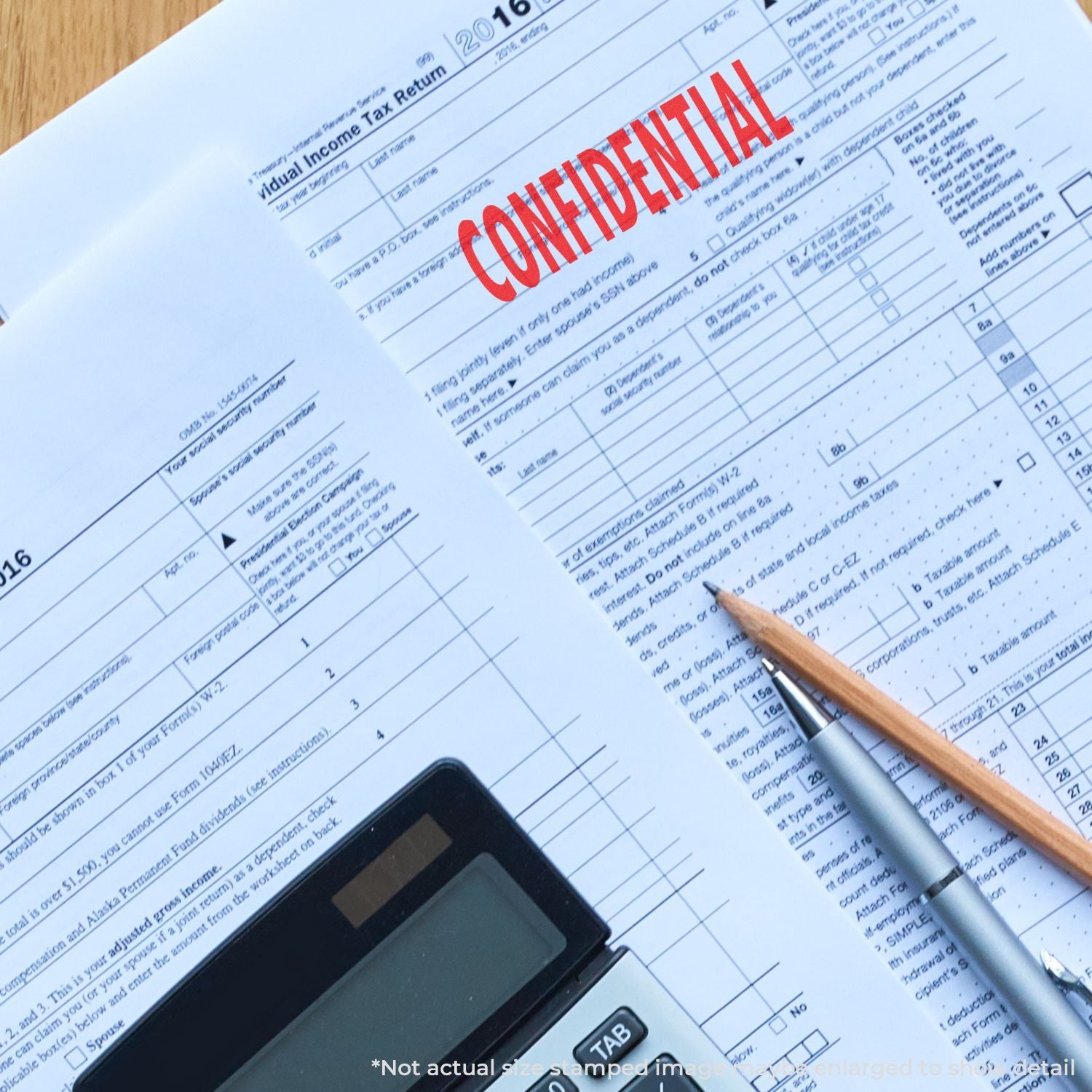 Confidential individual income tax return form with calculator, pen, and pencil on a desk.