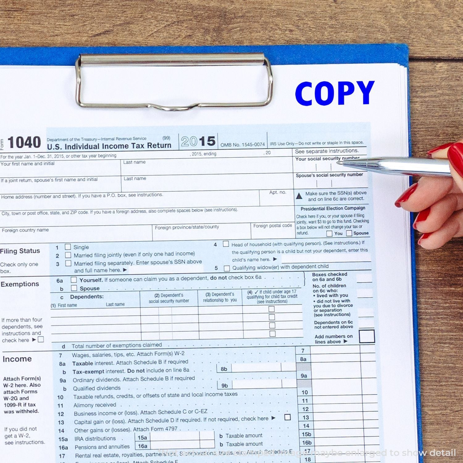 U.S. IRS Form 1040 copy on clipboard with pen, showing individual income tax return preparation for filing and review.