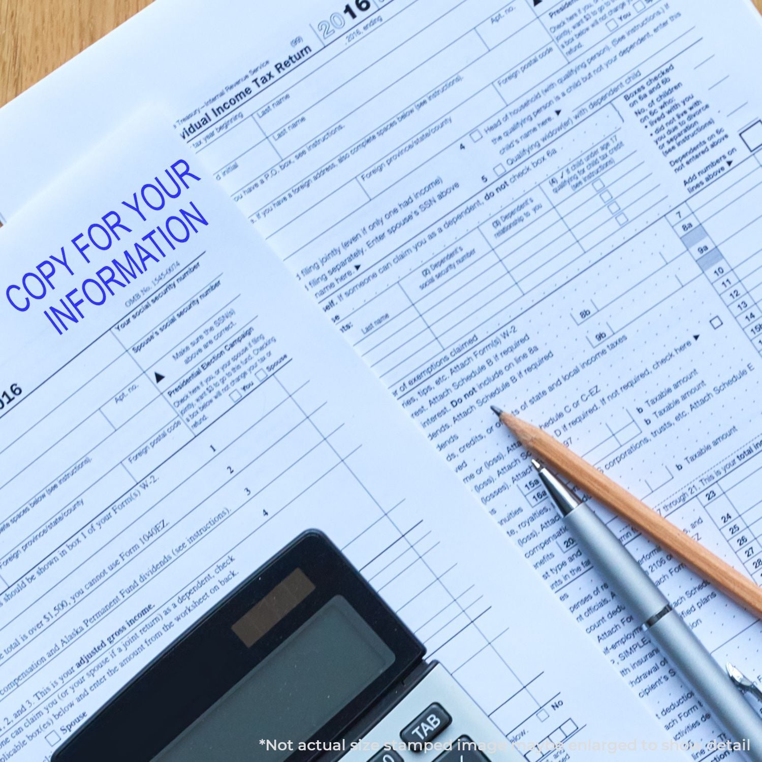 IRS income tax return form with calculator, pens, and copy for your information stamp on a desk.