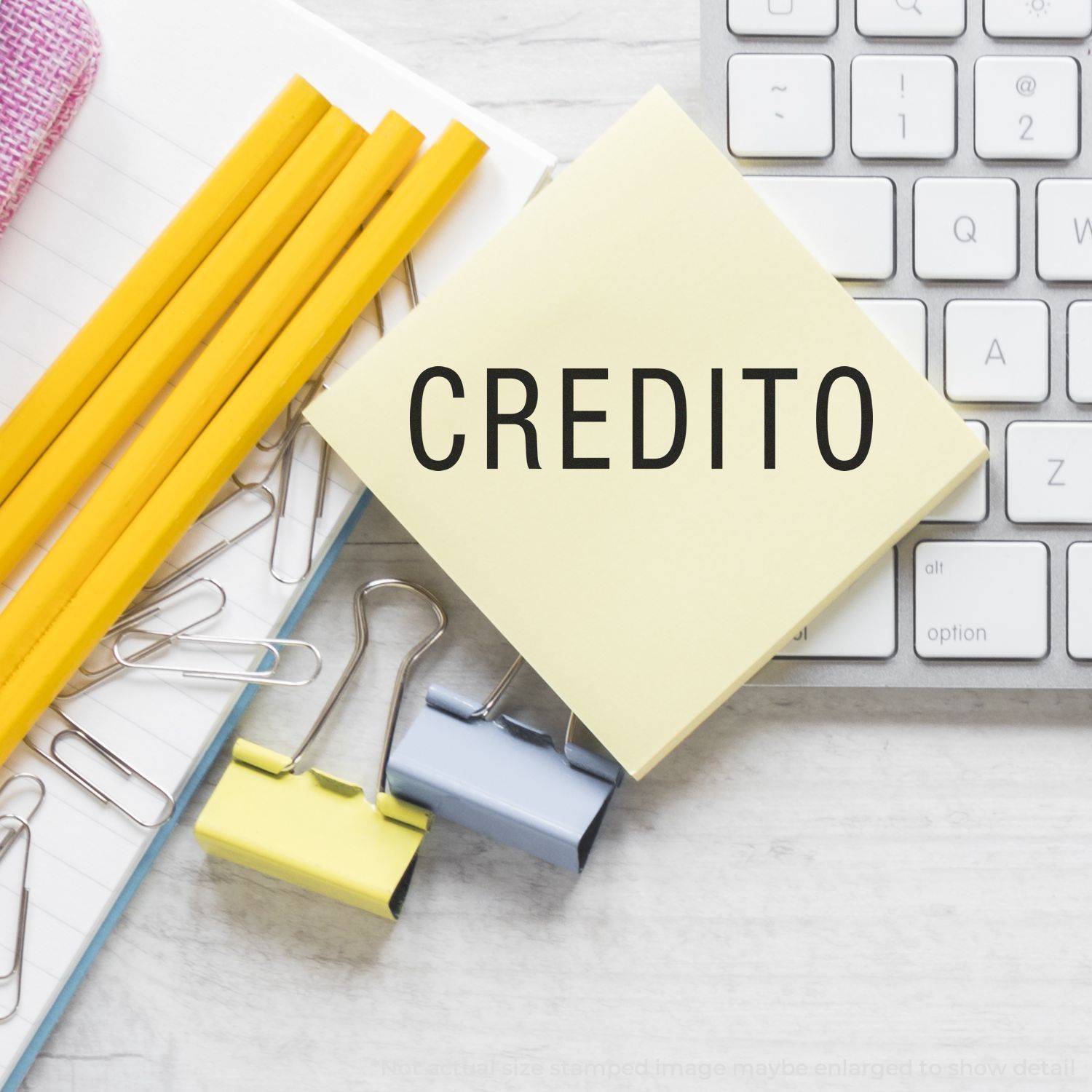Sticky note with CREDITO on a keyboard, surrounded by office supplies, finance and business concept image.