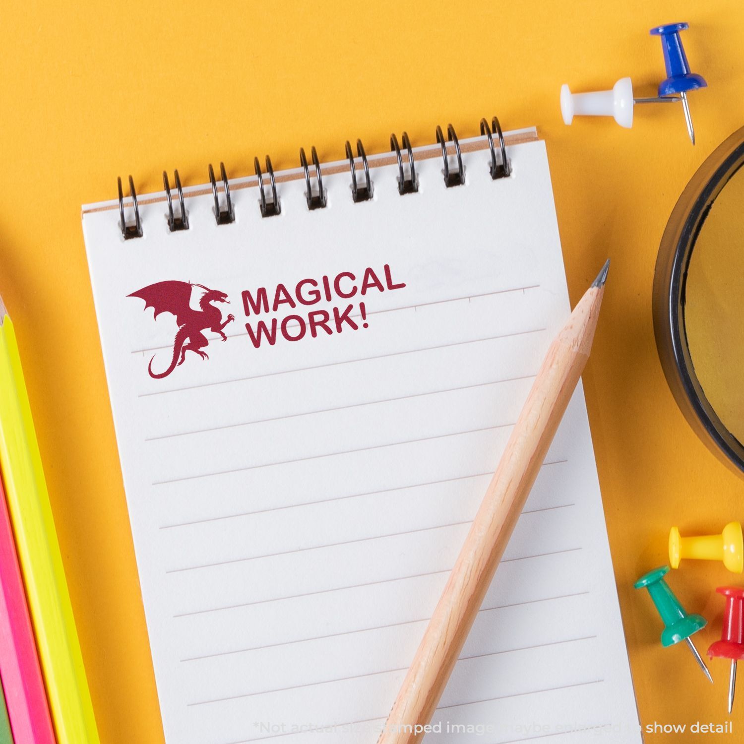 Top view of notebook with MAGICAL WORK! text, dragon logo, pencil and office supplies for creative productivity concept.