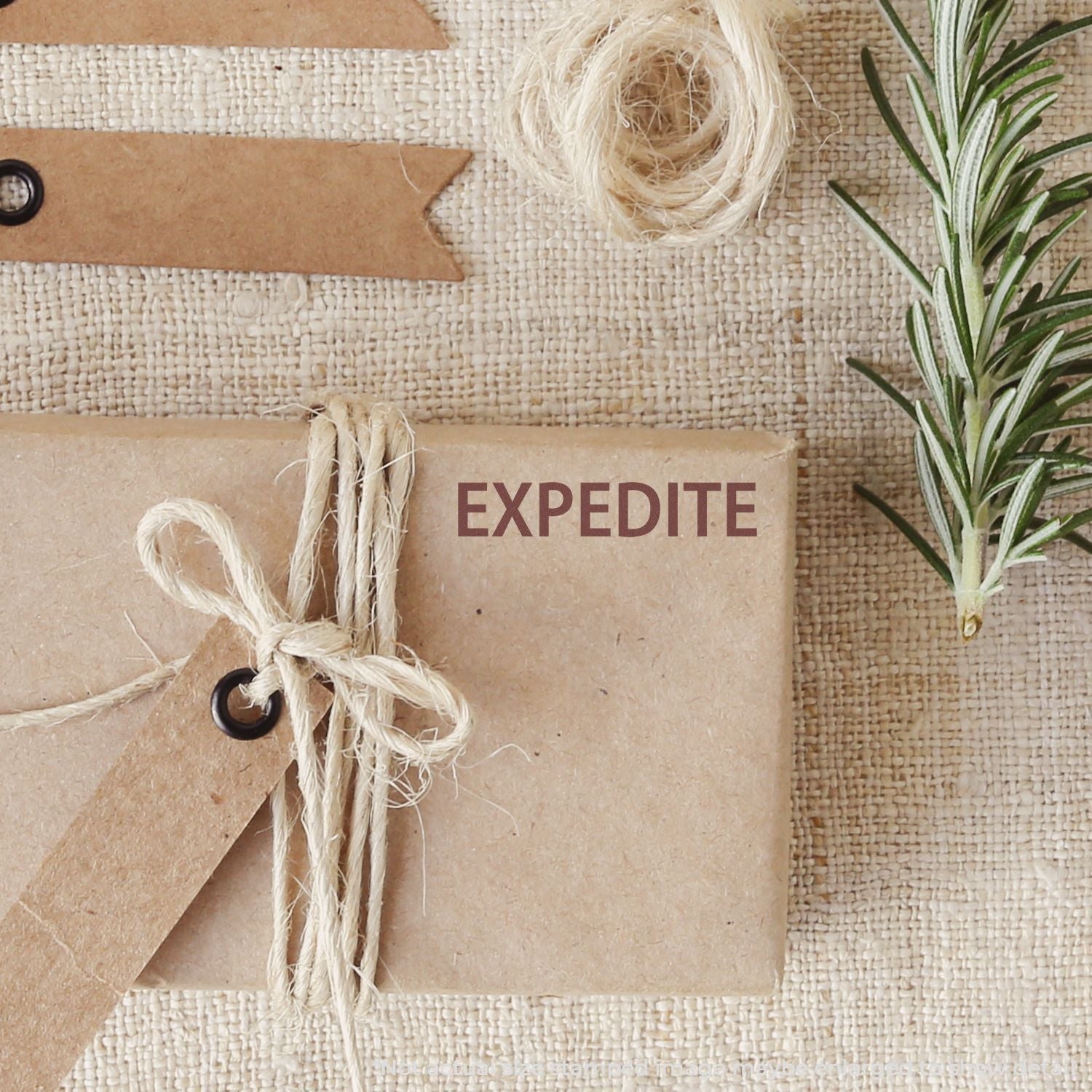 EXPEDITE shipping message on kraft gift box tied with twine, set on burlap with small succulentfast delivery promotion for online orders