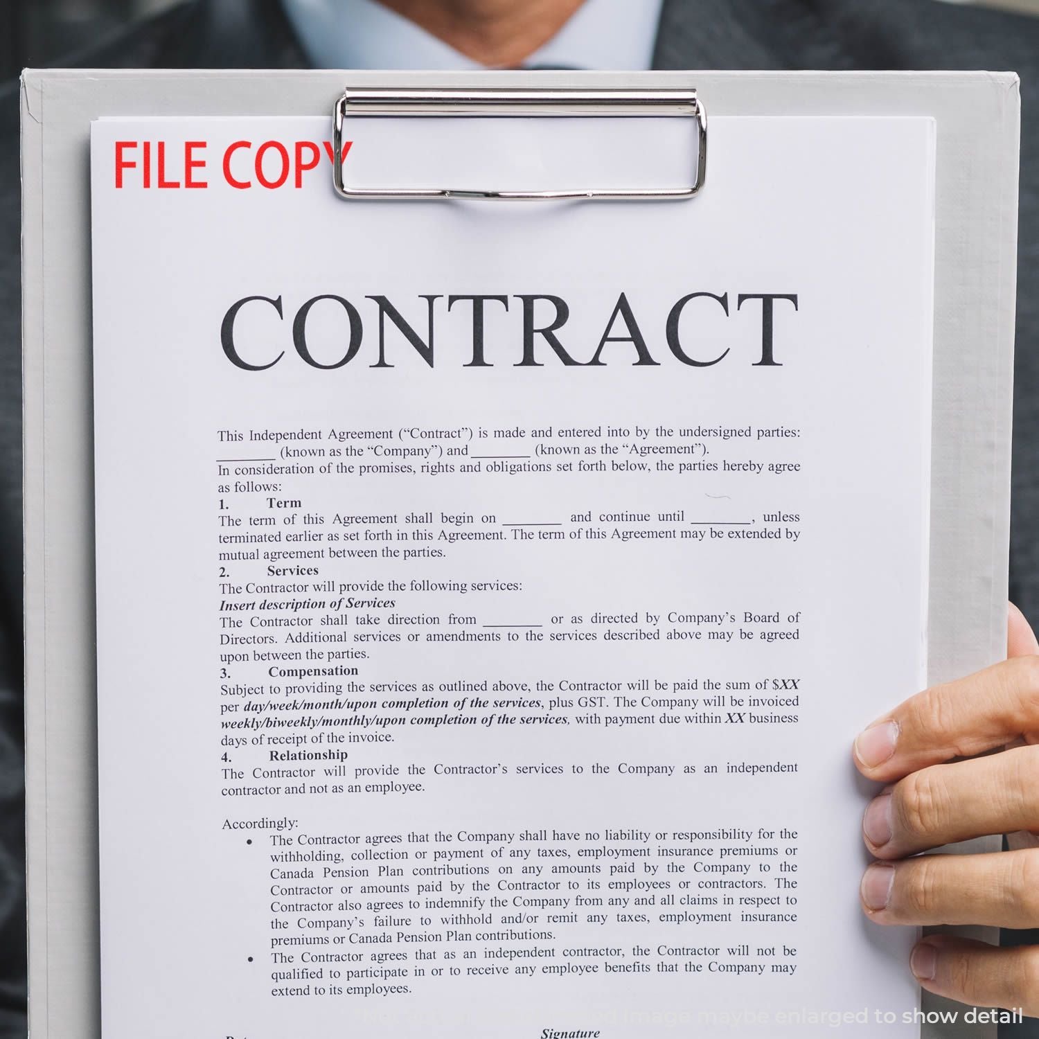 Hand holding contract agreement document on clipboard, independent contractor file copy showing business services terms and signature section