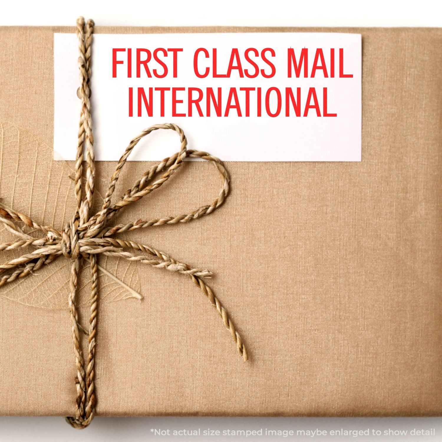 First Class Mail International package wrapped in kraft paper with twine bow and red shipping label.
