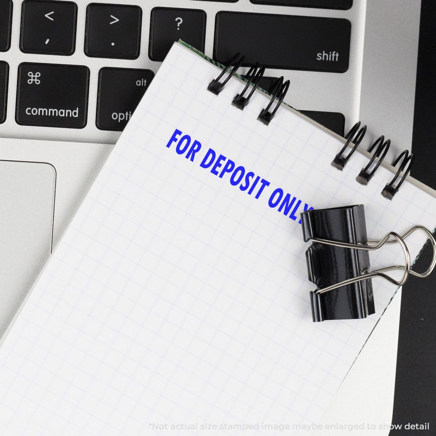 For deposit only stamp on a notebook/ledger page beside a computer keyboard, suggesting secure banking deposit processing.