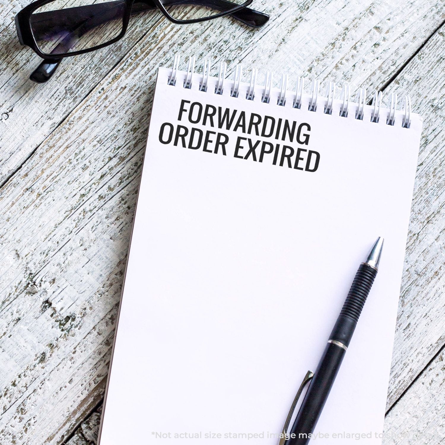 Notebook page reading Forwarding Order Expired with pen and glasses on wooden desk, indicating a shipping forwarding delivery notice