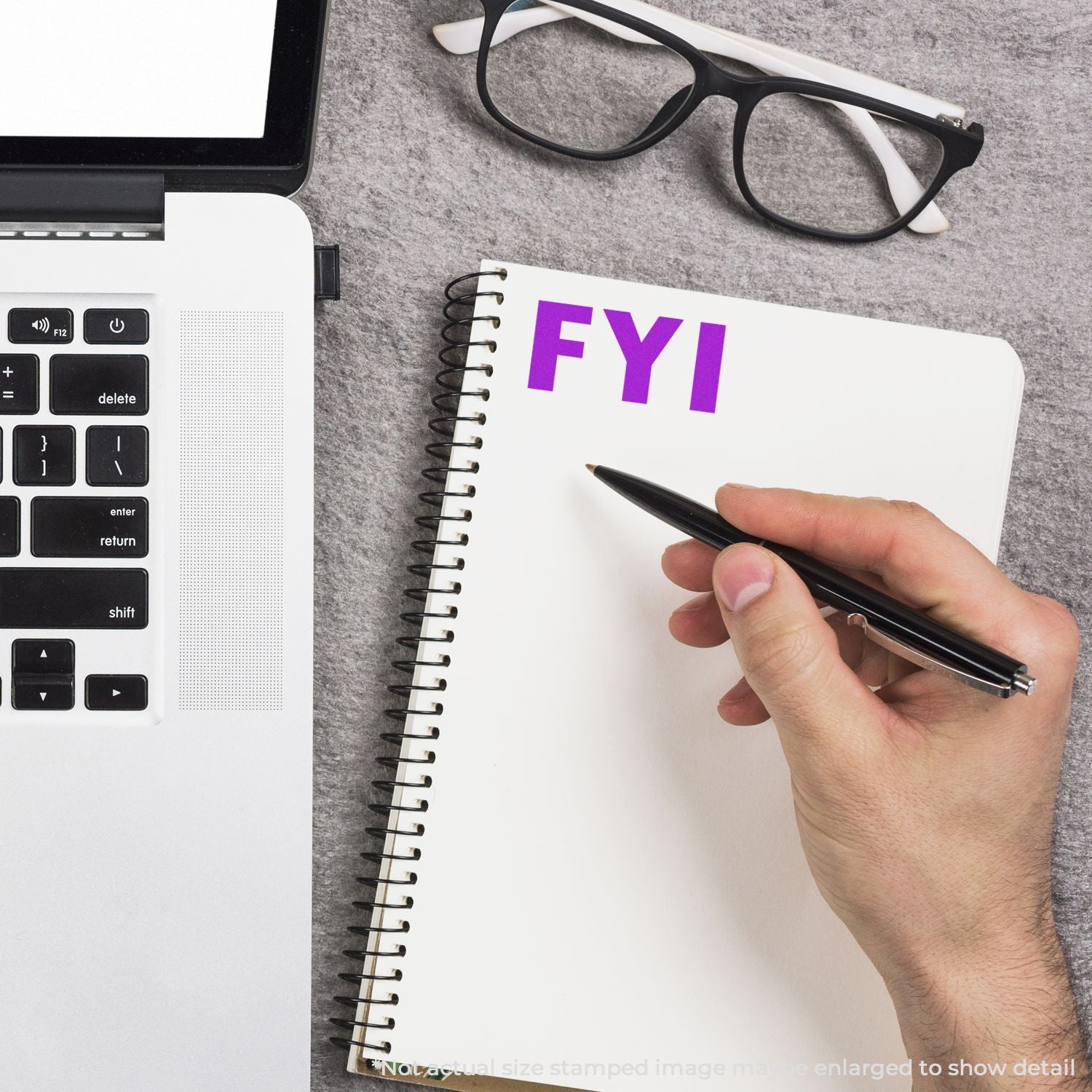 Hand writing on notebook with FYI label, alongside calculator and glassesoffice productivity and note-taking concept.