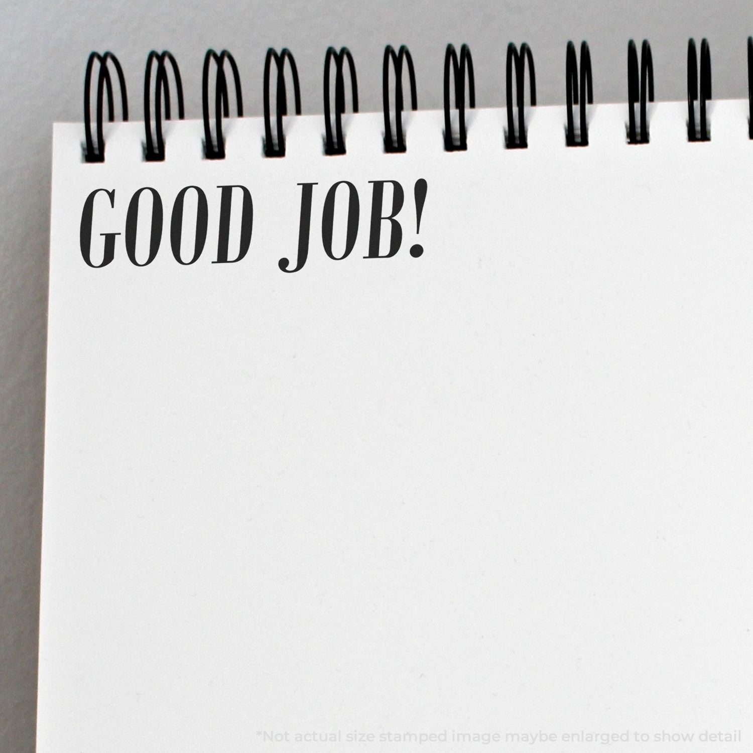 Spiral notebook page with GOOD JOB! text, motivational note on blank white paper.