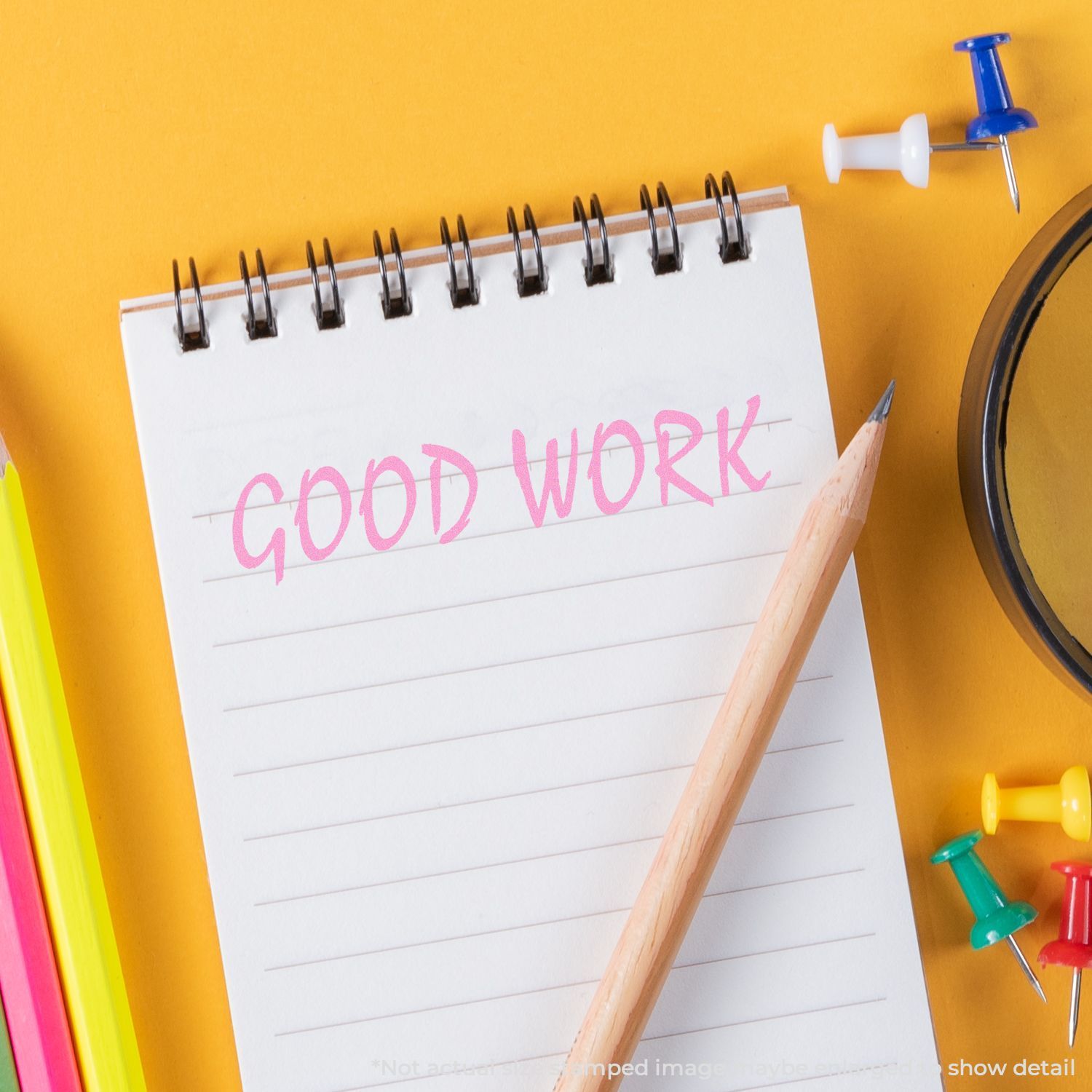 Motivational desk scene: notepad reading Good Work with pencil and stationery on a bright yellow background.