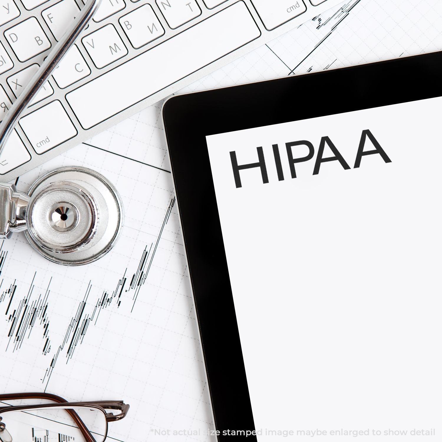 HIPAA compliance concept with tablet screen, stethoscope, keyboard, eyeglasses, and medical chart on a desk.