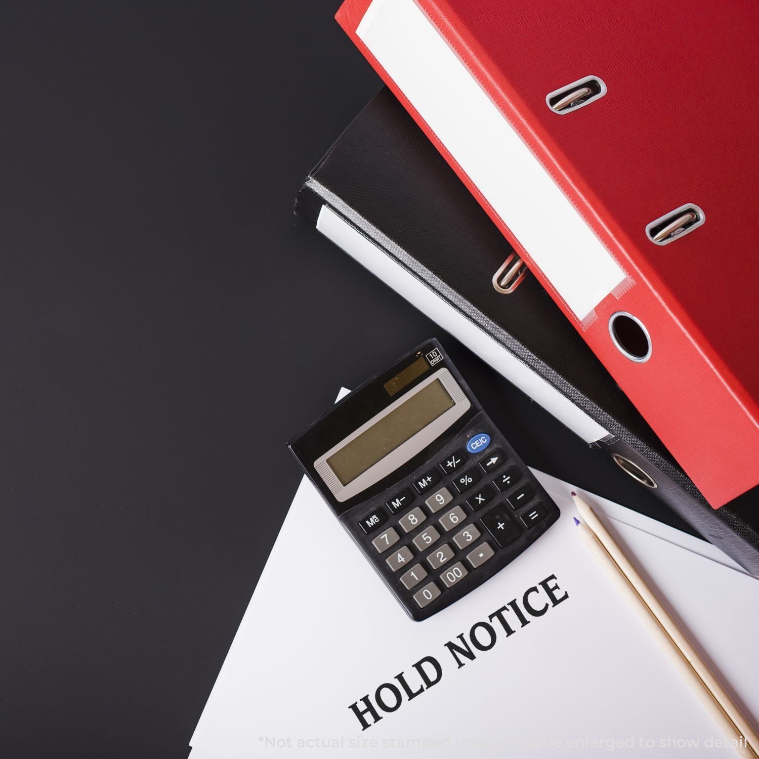Hold notice document with calculator, pencils, and red office binders on a dark desk background.