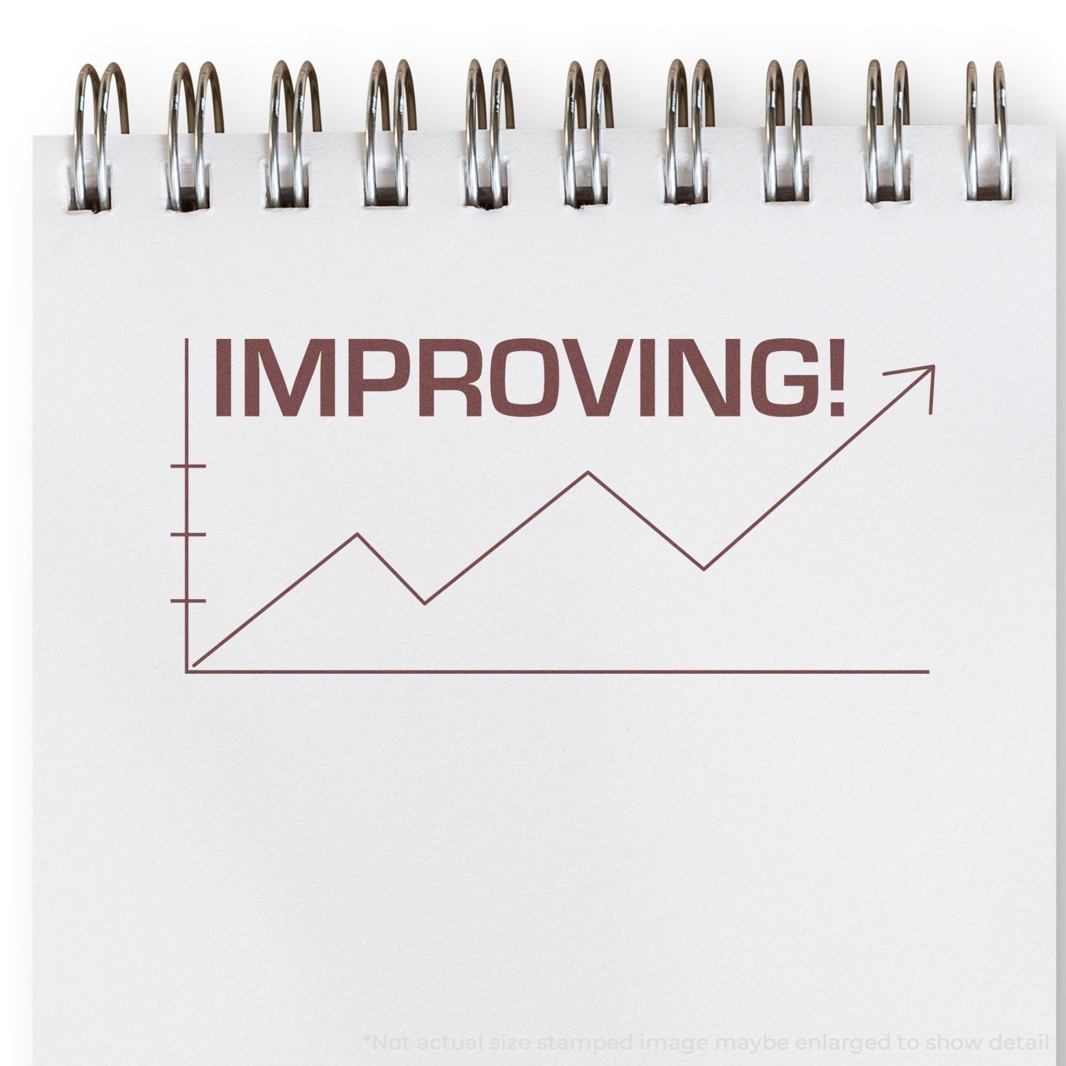 Spiral notebook page with IMPROVING! and an upward trend line chart, symbolizing business growth and progress.