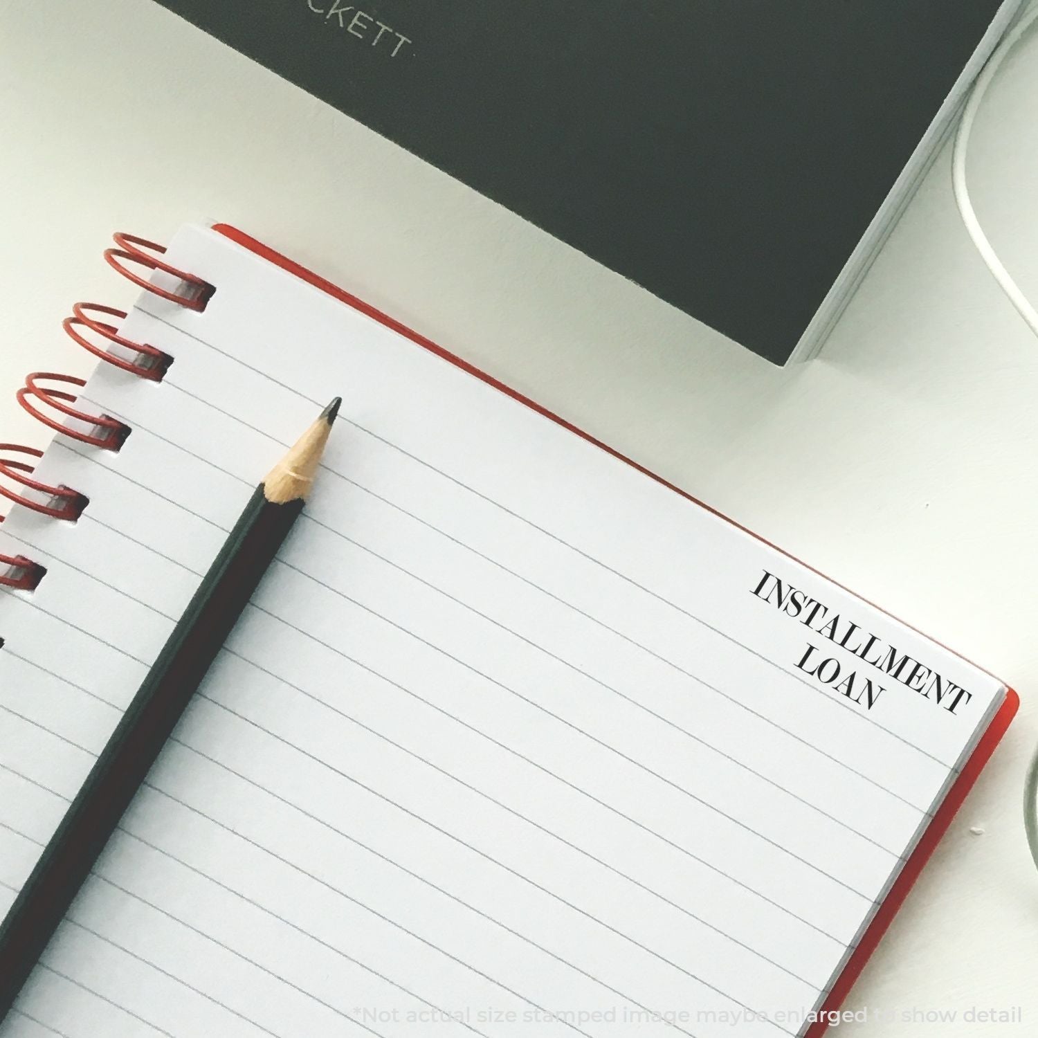 Installment loan notes on a notebook page, with pencil, highlighting installment financing and repayment planning for borrowers.