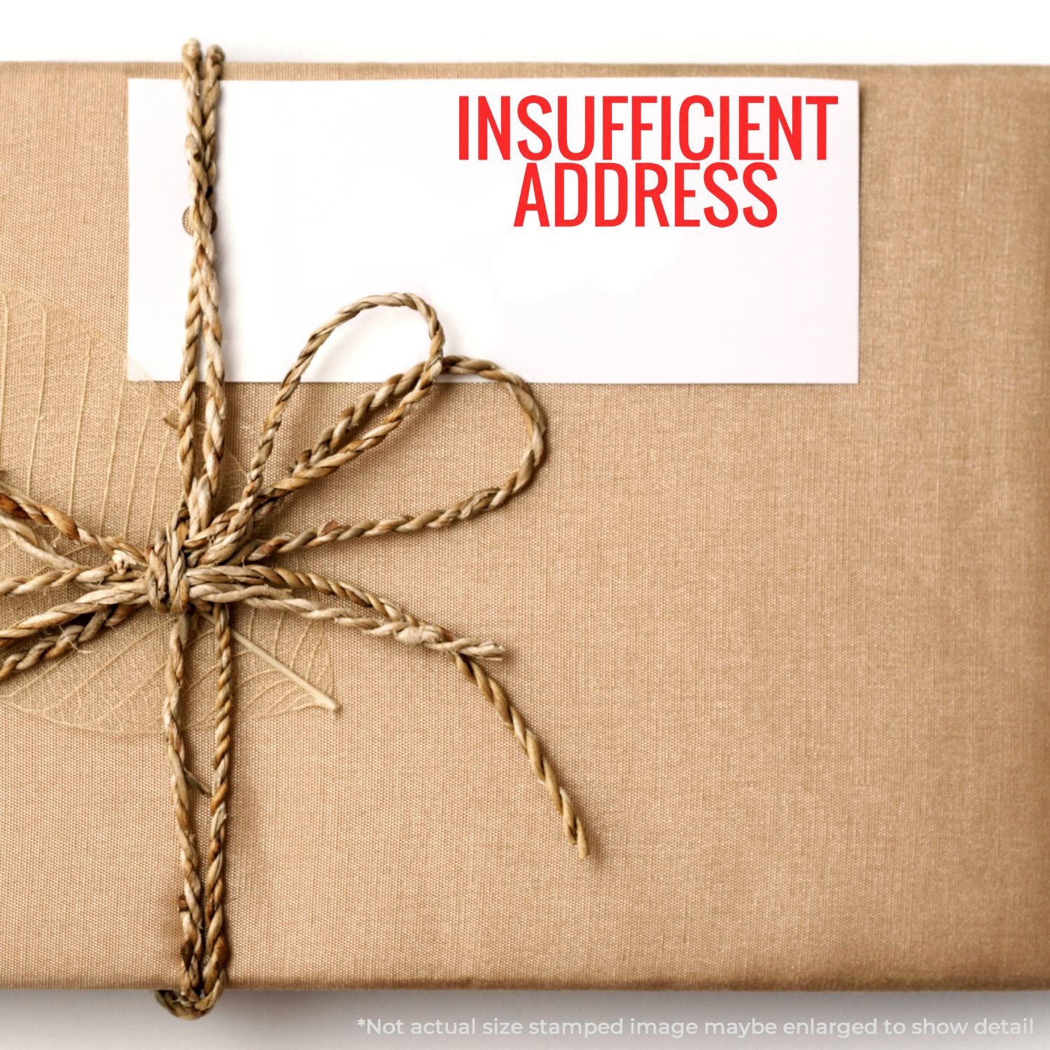 Insufficient address notice on a wrapped shipping box with twine, showing an address label for mail return or USPS delivery failure.