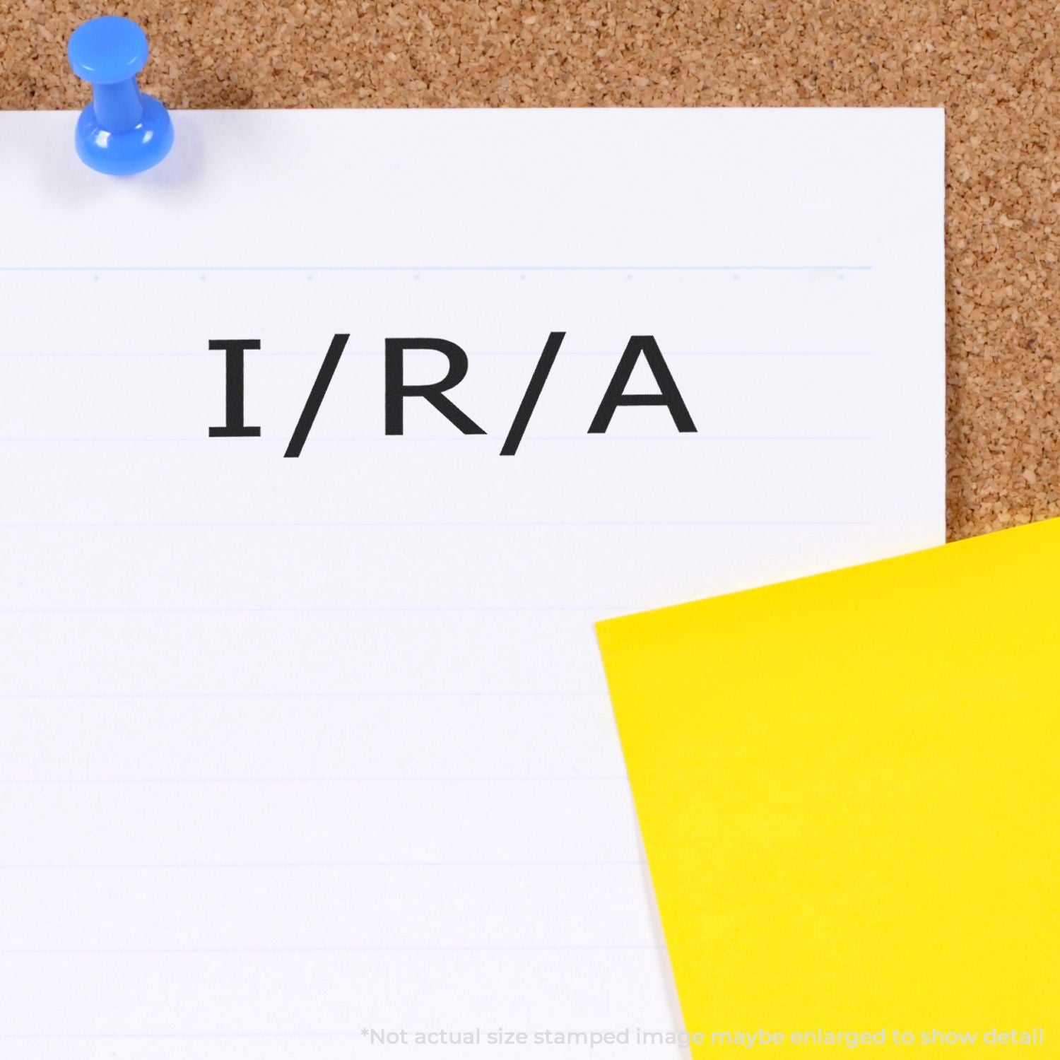 IRIA word printed on a note pinned with a blue pushpin on a corkboard, with a yellow paper corner in view