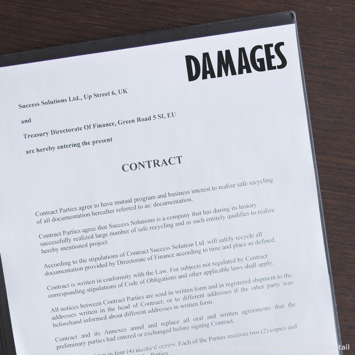 Legal contract document on a desk showing DAMAGES heading, indicating enforceable terms for liabilities and compensation.