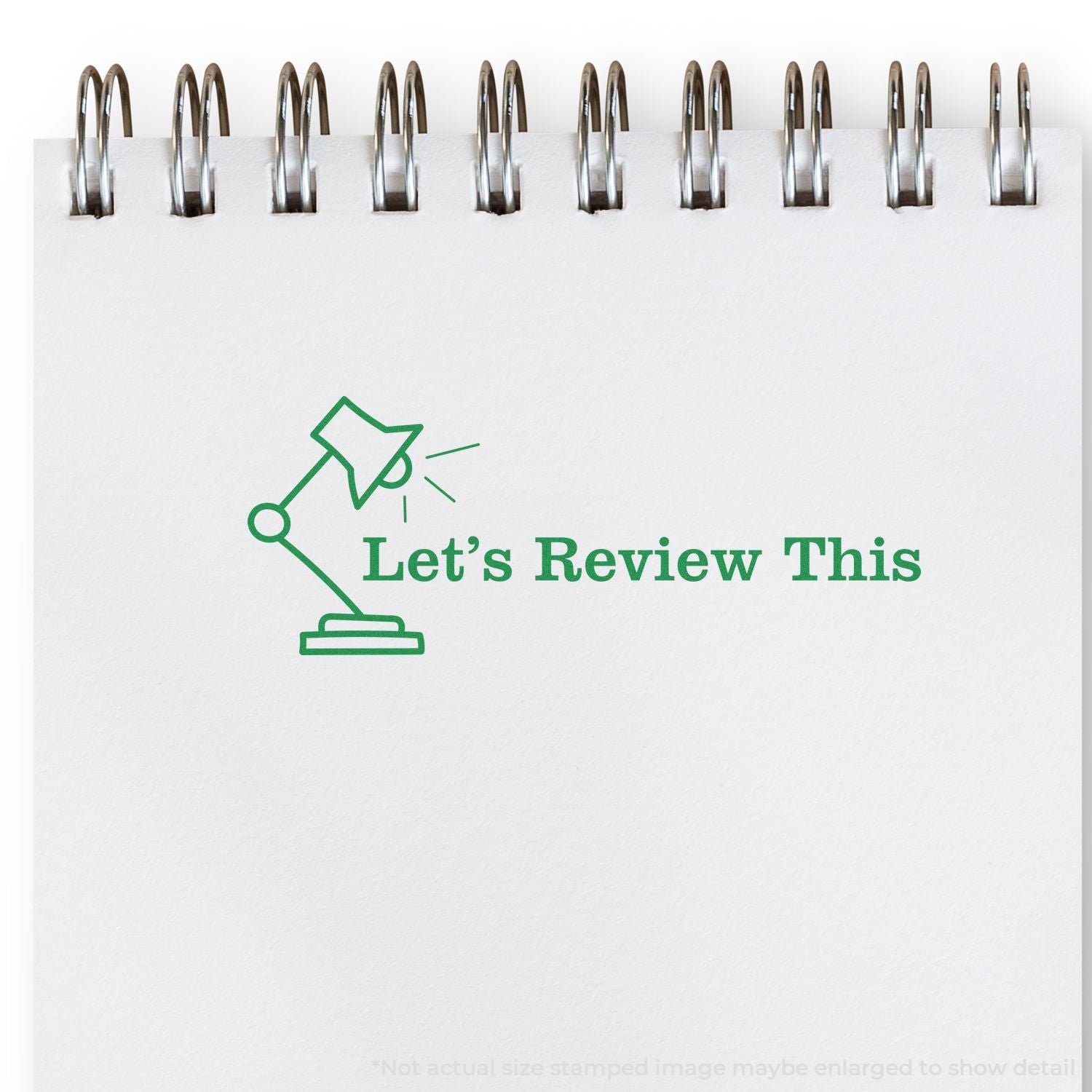 Spiral notebook page with green desk lamp icon and Lets Review This text on a white background.