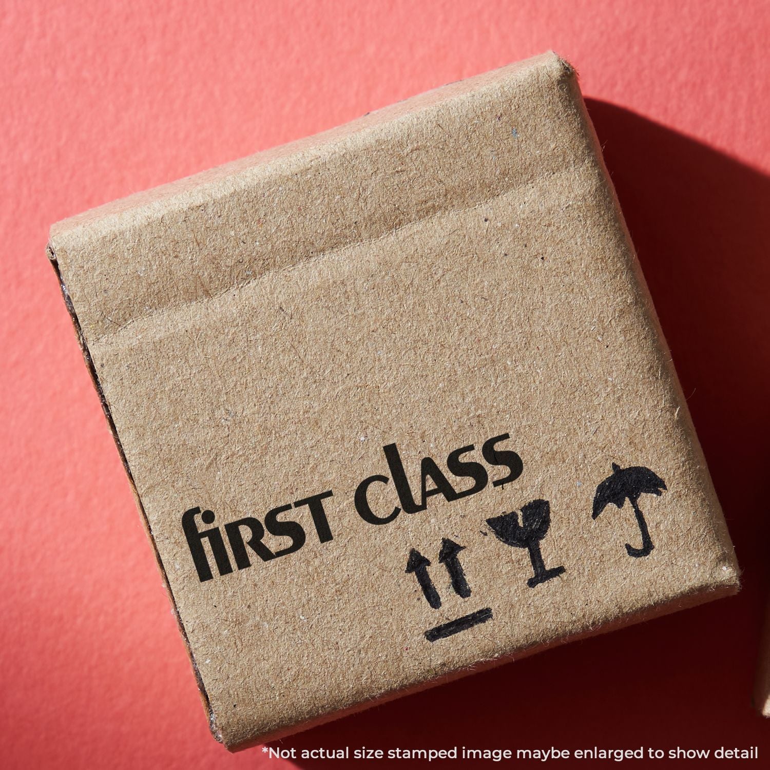 First class cardboard shipping box on a red background with fragile handling symbols.