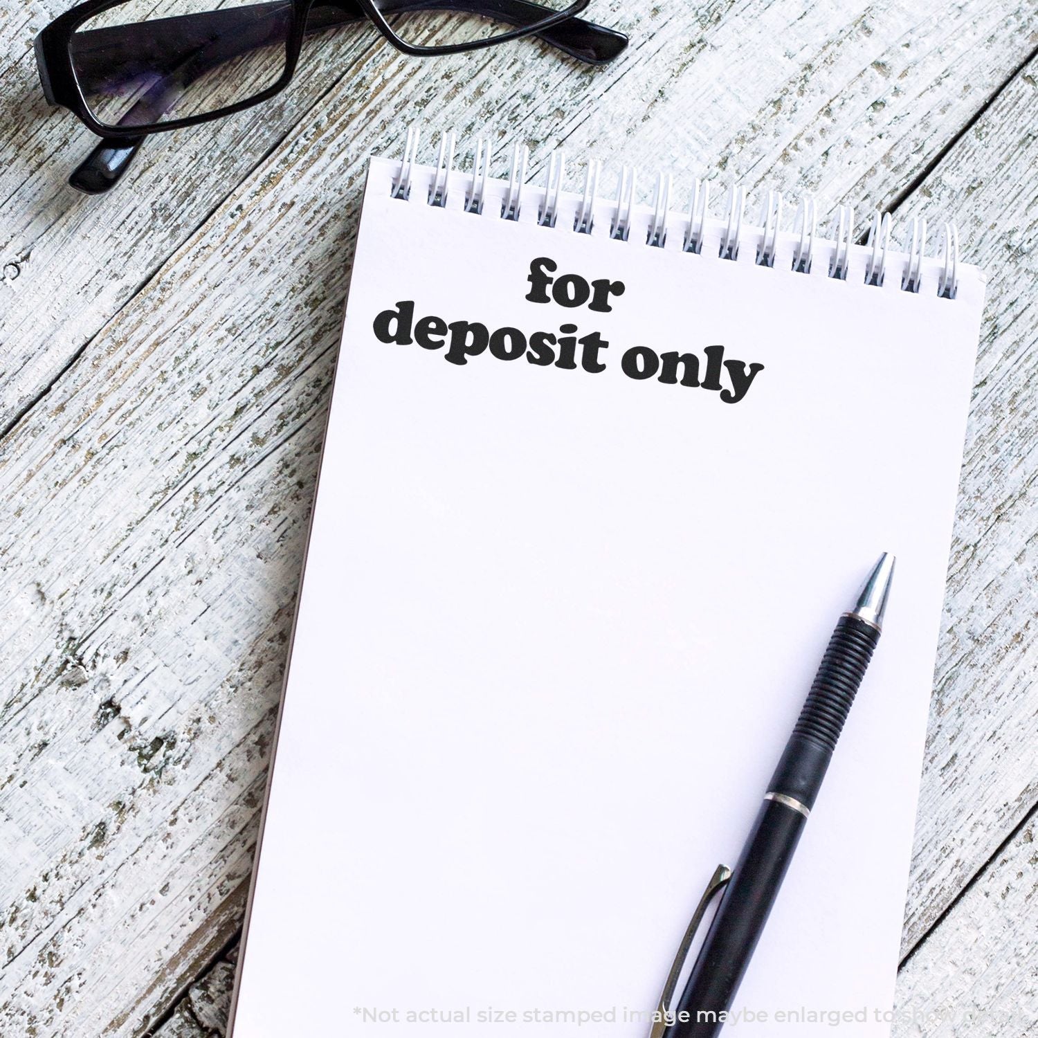 Notepad labeled For Deposit Only with pen and glasses on a wooden desk, highlighting a banking deposit-only document.