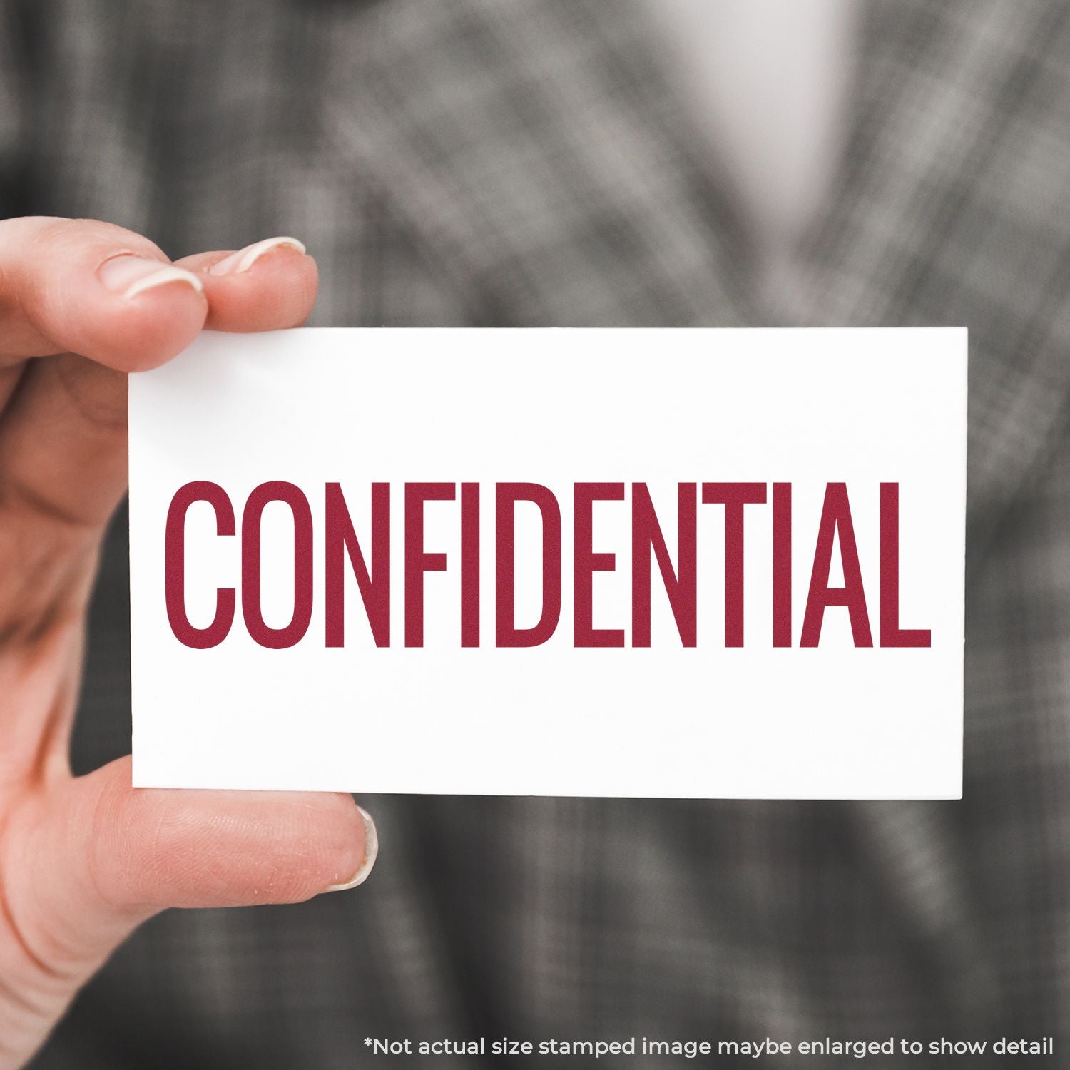 Hand holding a CONFIDENTIAL stamped note, highlighting document security and private information handling.