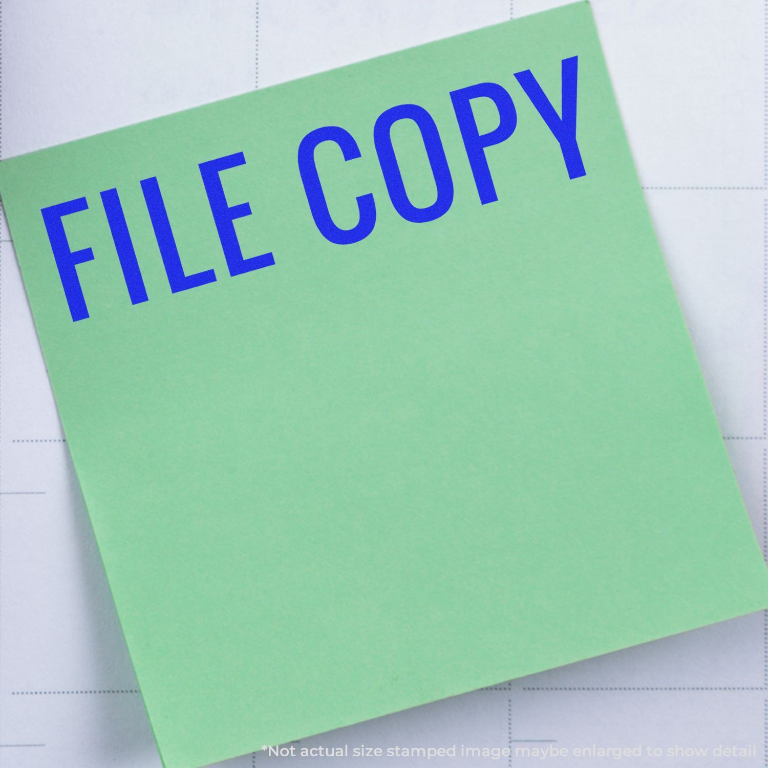 Green sticky note labeled FILE COPY on gridded paper background, office document copy concept.