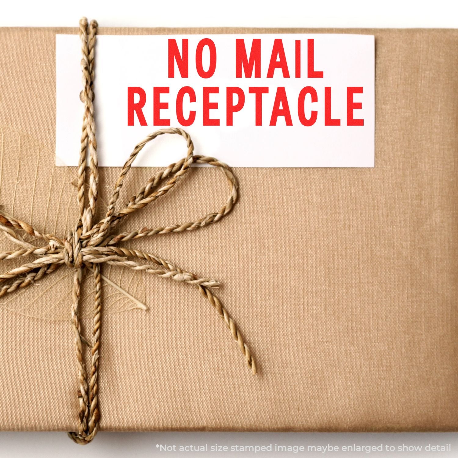 No mail receptacle warning on rope-tied cardboard parcel, indicating blocked delivery or undeliverable address.