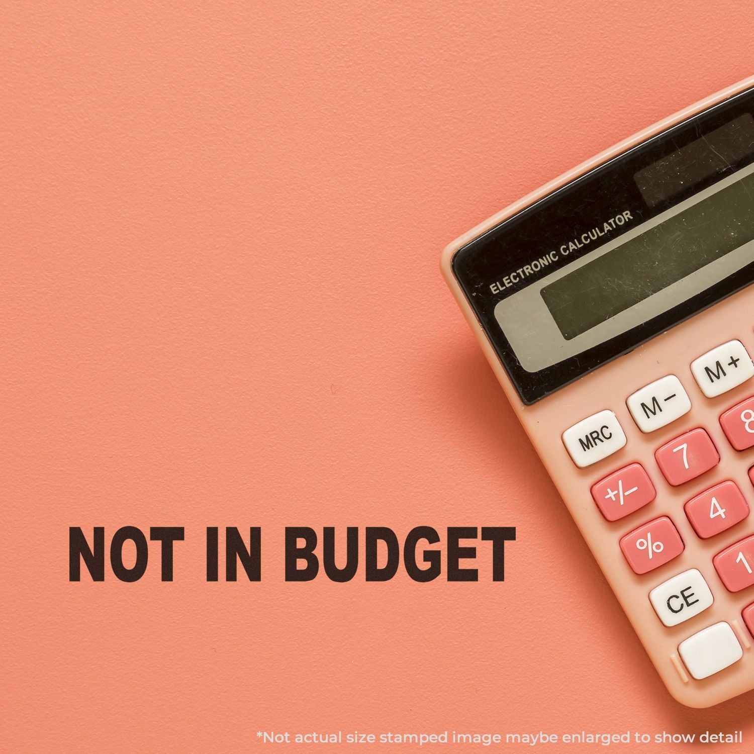 Pink calculator with Not in Budget text on coral background, budget and finance concept.