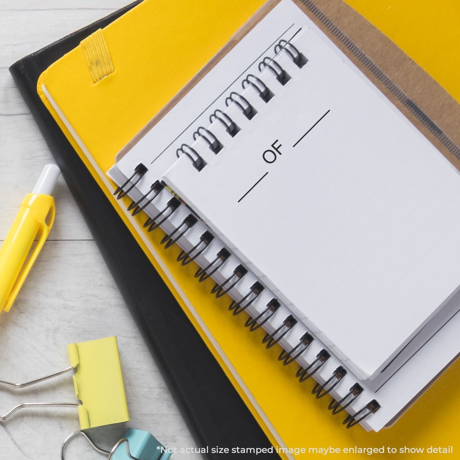 Yellow spiral notebook with paper clips and tabbed pages for organizing notes and study schedules