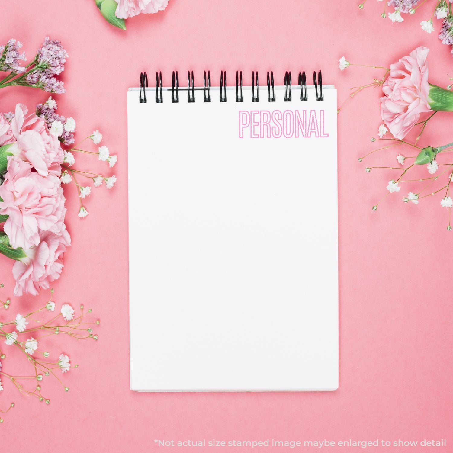 Personal journal notebook labeled PERSONAL on pink background with pink flowers, blank page for writing and planning near spring floral decor