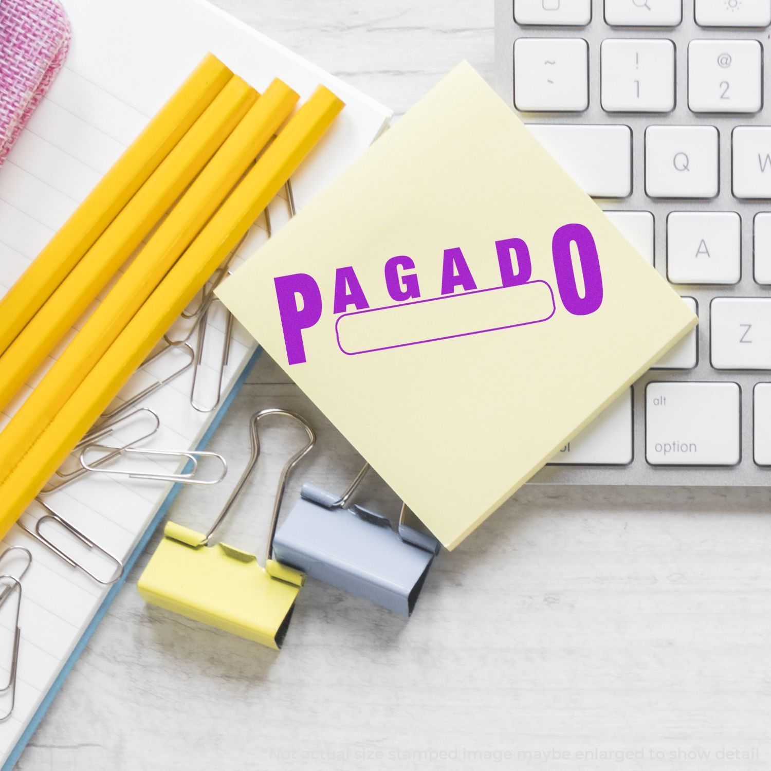Paid invoice confirmation: PAGADO stamp on stationery with yellow pencils, paperclips, and a computer keyboard, for accounting payments.