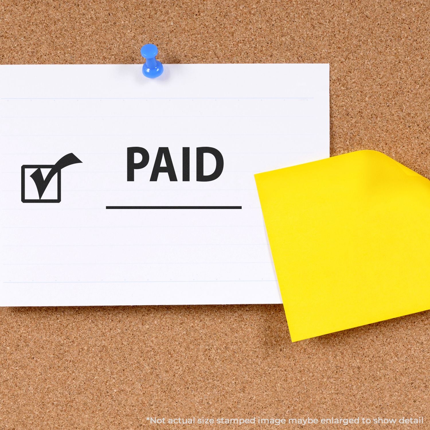 Paid stamp on pinned paper with yellow sticky note on cork bulletin board