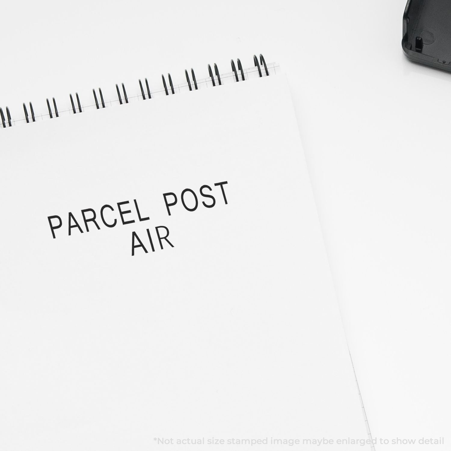 Parcel shipping label on white notebook cover reading PARCEL POST AIR, suggesting air mail logistics and postal delivery services.