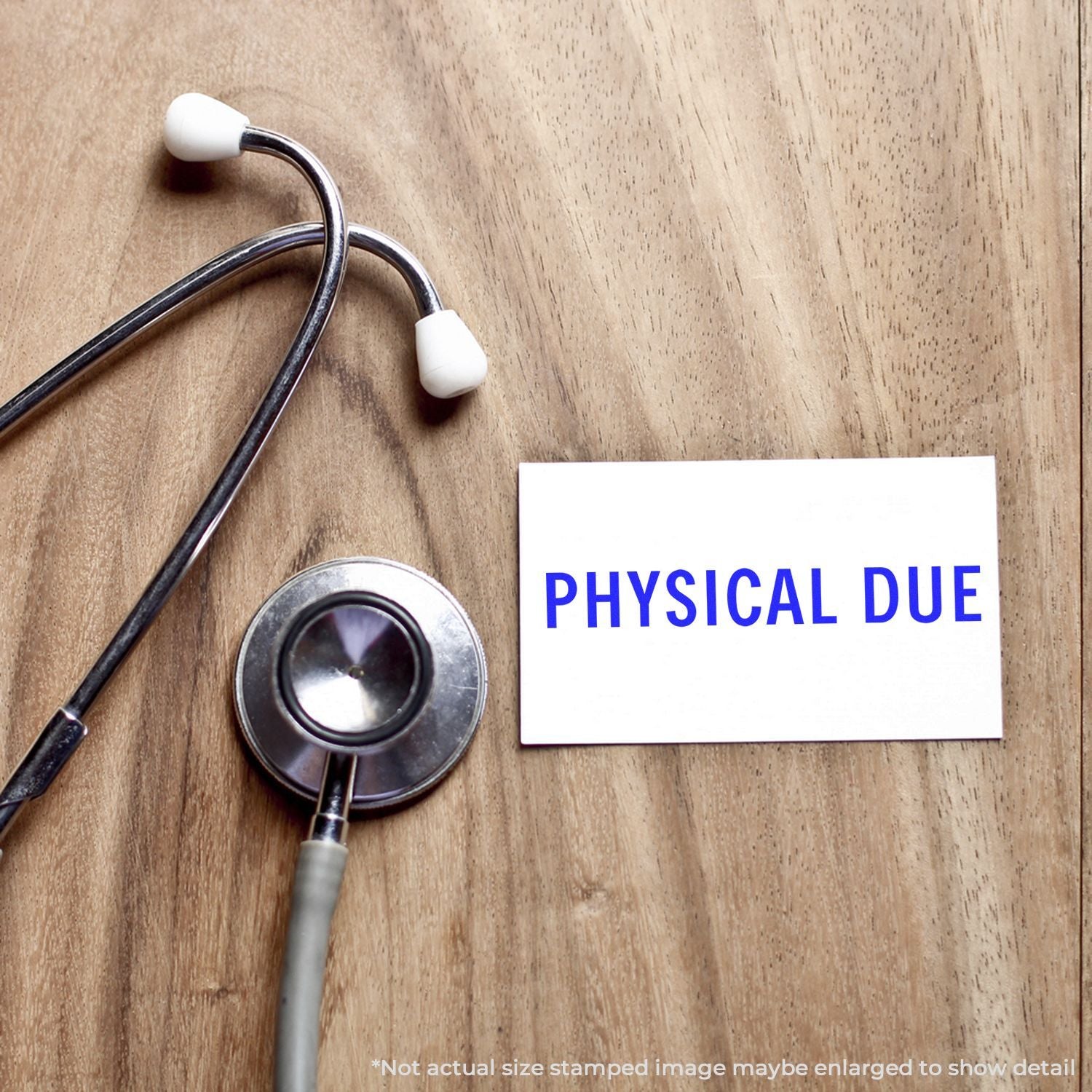 Stethoscope with Physical Due reminder card on wooden desk, promoting scheduling for an upcoming medical physical exam.