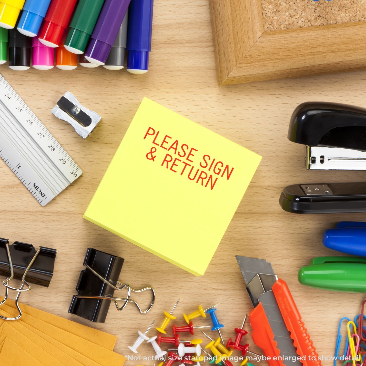 Office stationery on desk with yellow note reading PLEASE SIGN & RETURN, stapler, markers, rulerdocument return reminder