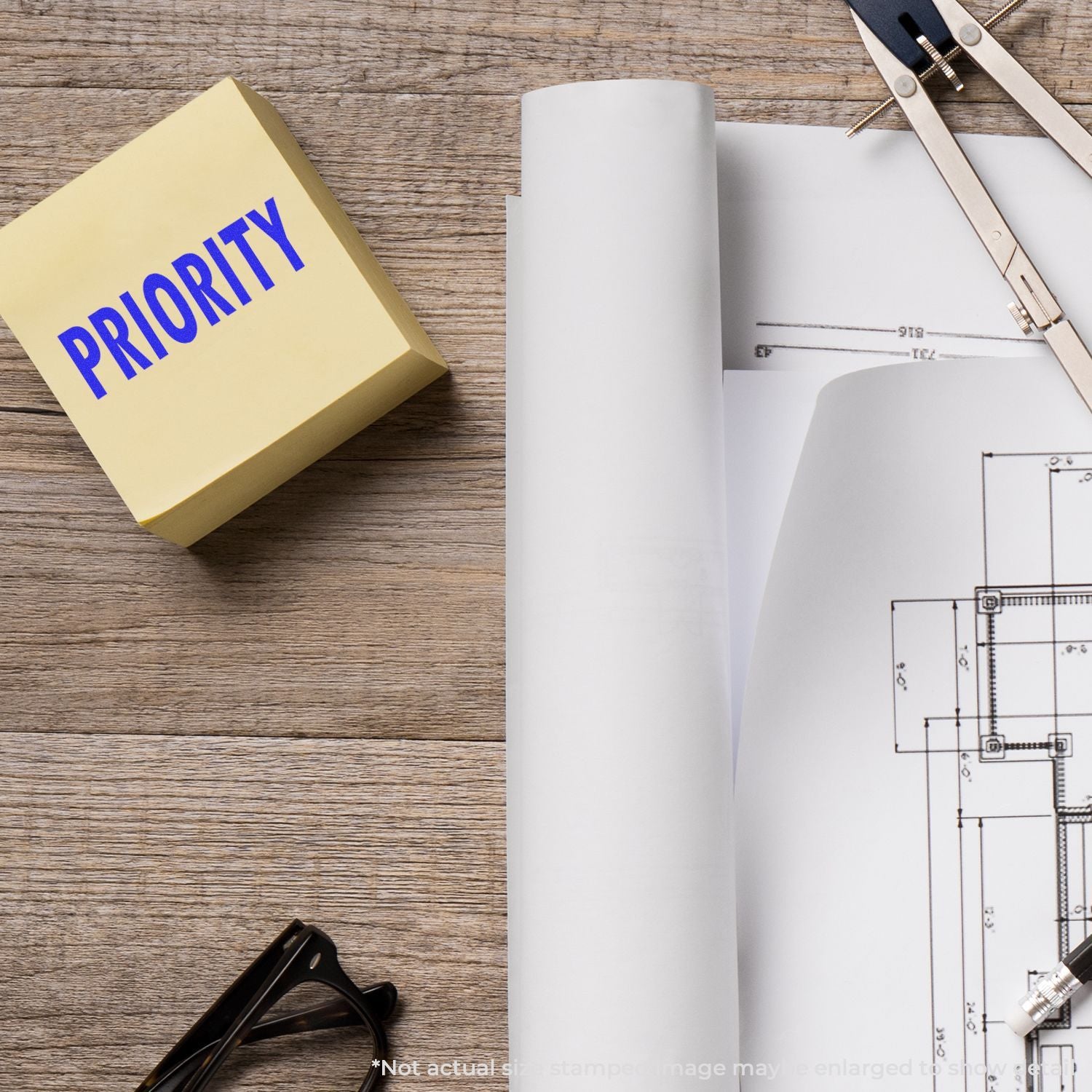 Construction project priority planning with engineering blueprint papers, tools, and "PRIORITY" label on a wooden desk for contractors.