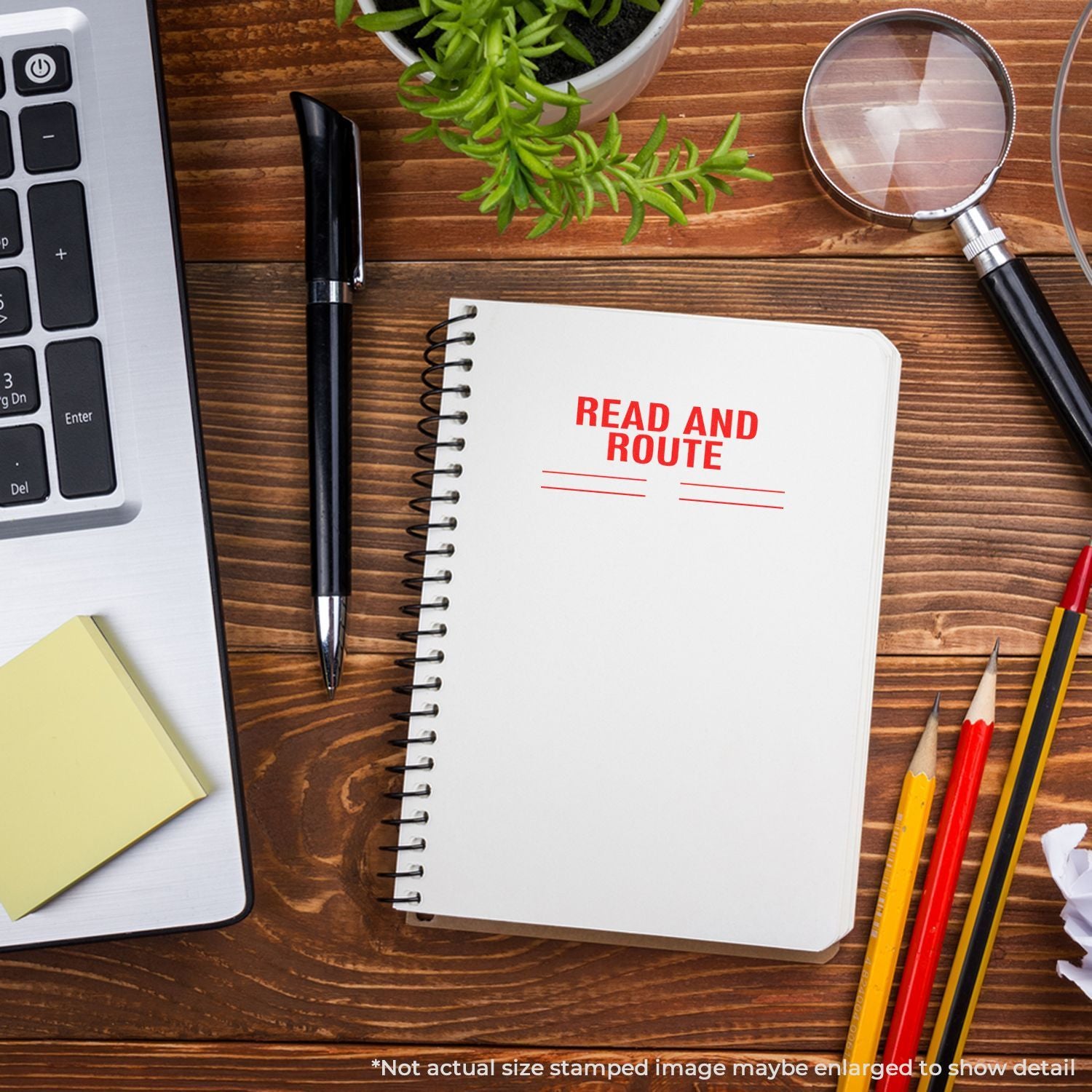 Notebook titled Read and Route on desk with laptop, magnifying glass, pens, and herbsplanning and study concept.