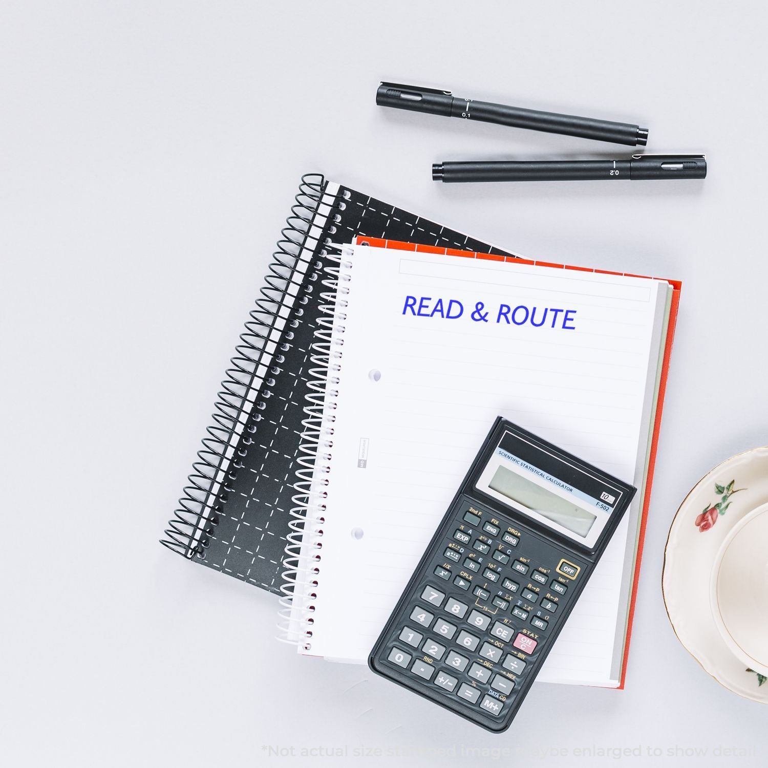 Flat lay of study notebooks, pens, and a scientific calculator on a white desk for planning and math work