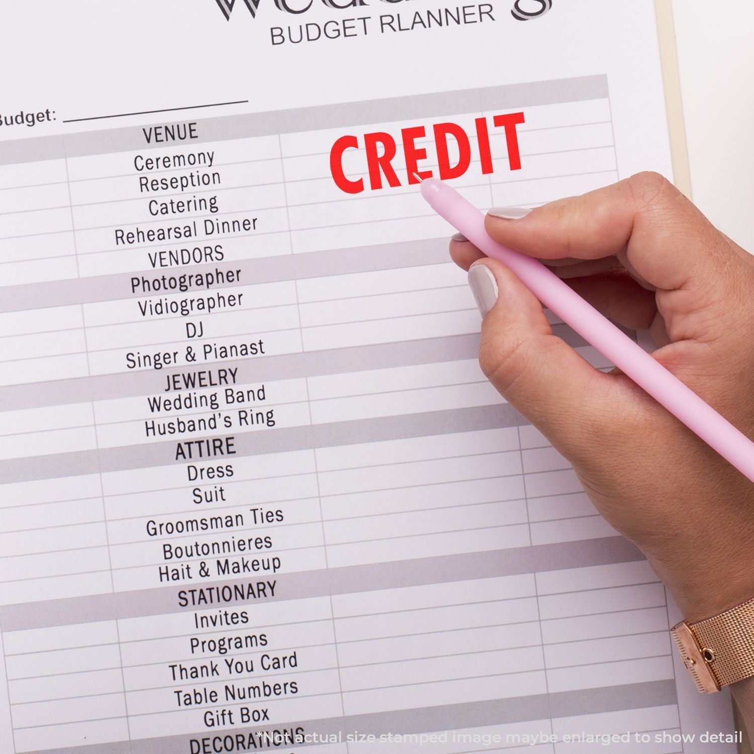Wedding budget planner page with hand marking credit, listing ceremony, vendors, catering, and wedding expense categories for planning