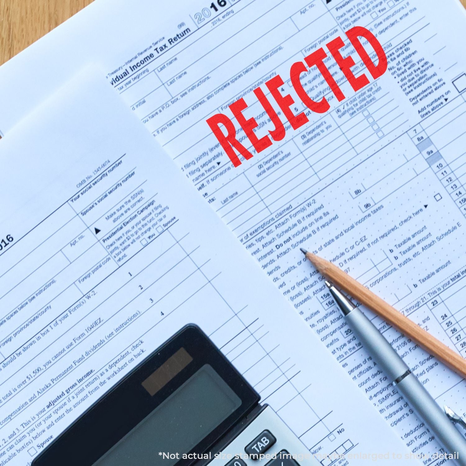 Rejected 2016 individual income tax return form with calculator and pens on desk